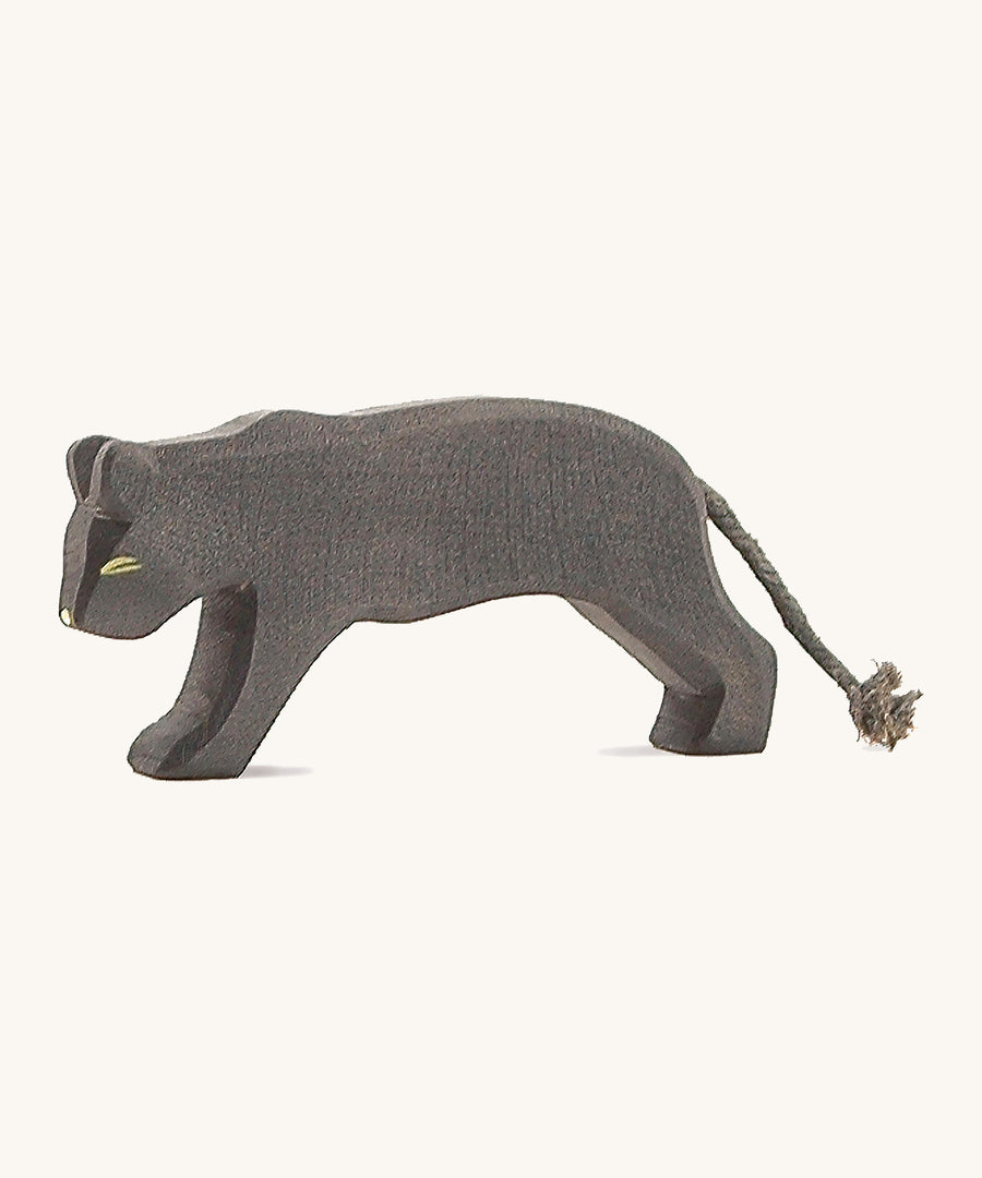 A wooden Ostheimer panther figure on a cream background.