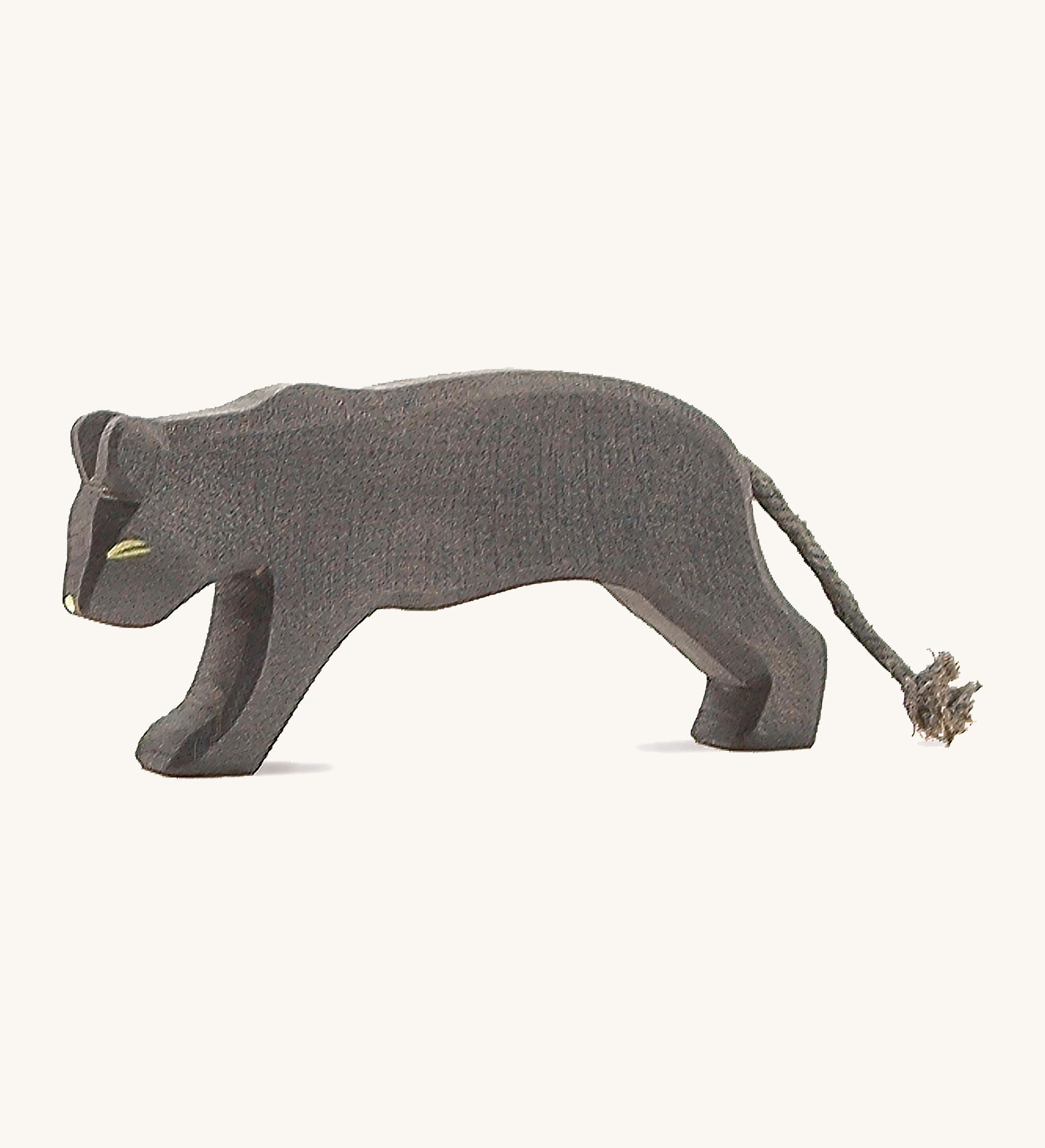 A wooden Ostheimer panther figure on a cream background.