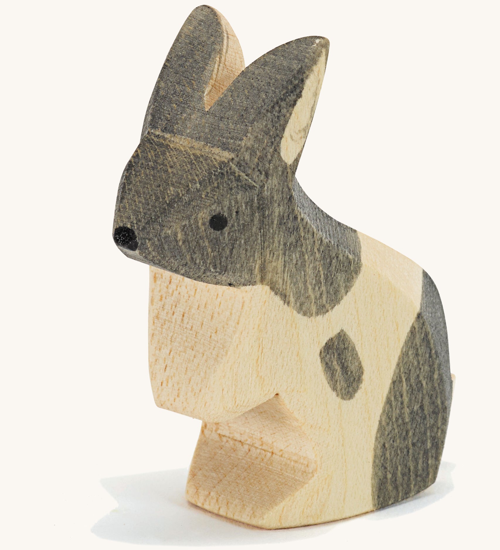 A wooden Ostheimer black and white standing rabbit figure on a cream background.