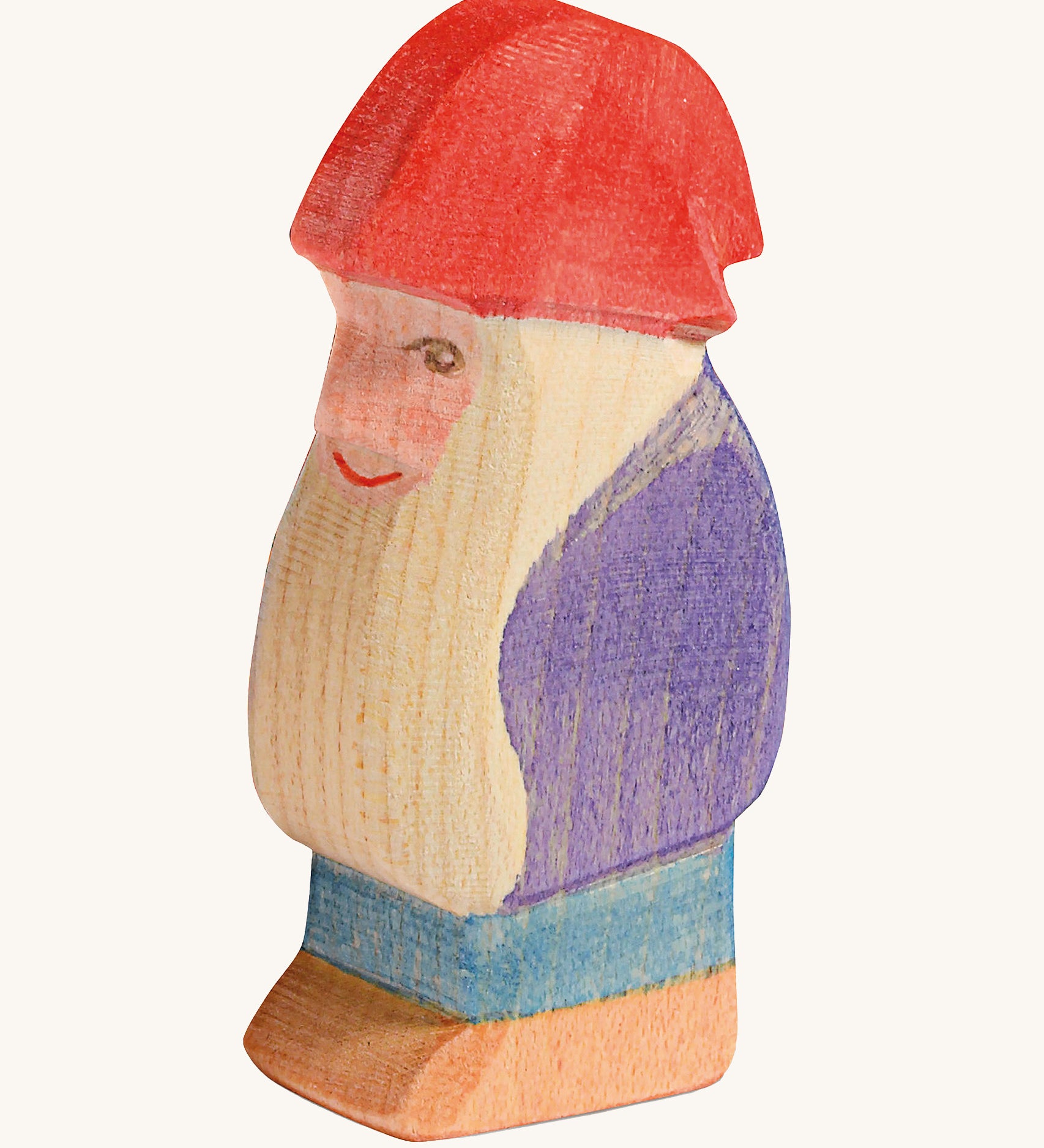 A wooden Ostheimer bodo dwarf figure wearing a purple coat, blue trousers and a red hat on a cream background.