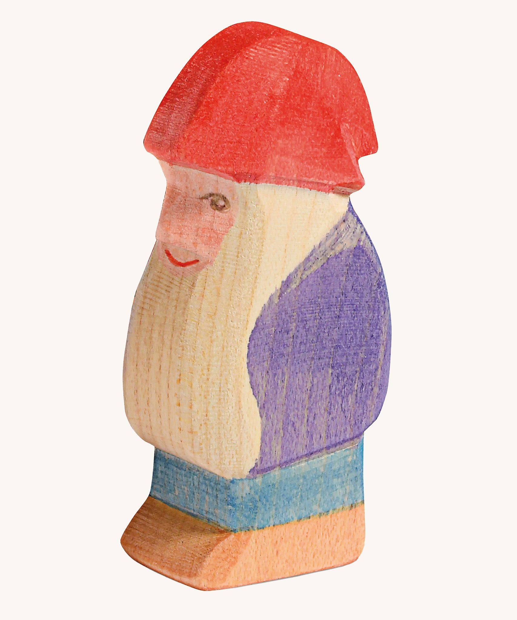 A wooden Ostheimer bodo dwarf figure wearing a purple coat, blue trousers and a red hat on a cream background.