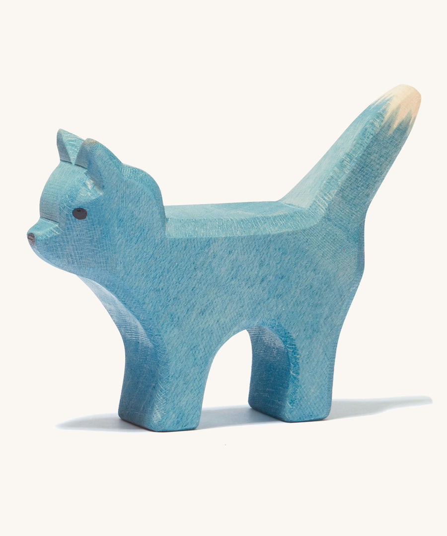 A blue wooden Ostheimer bremer standing cat figure on a cream background.