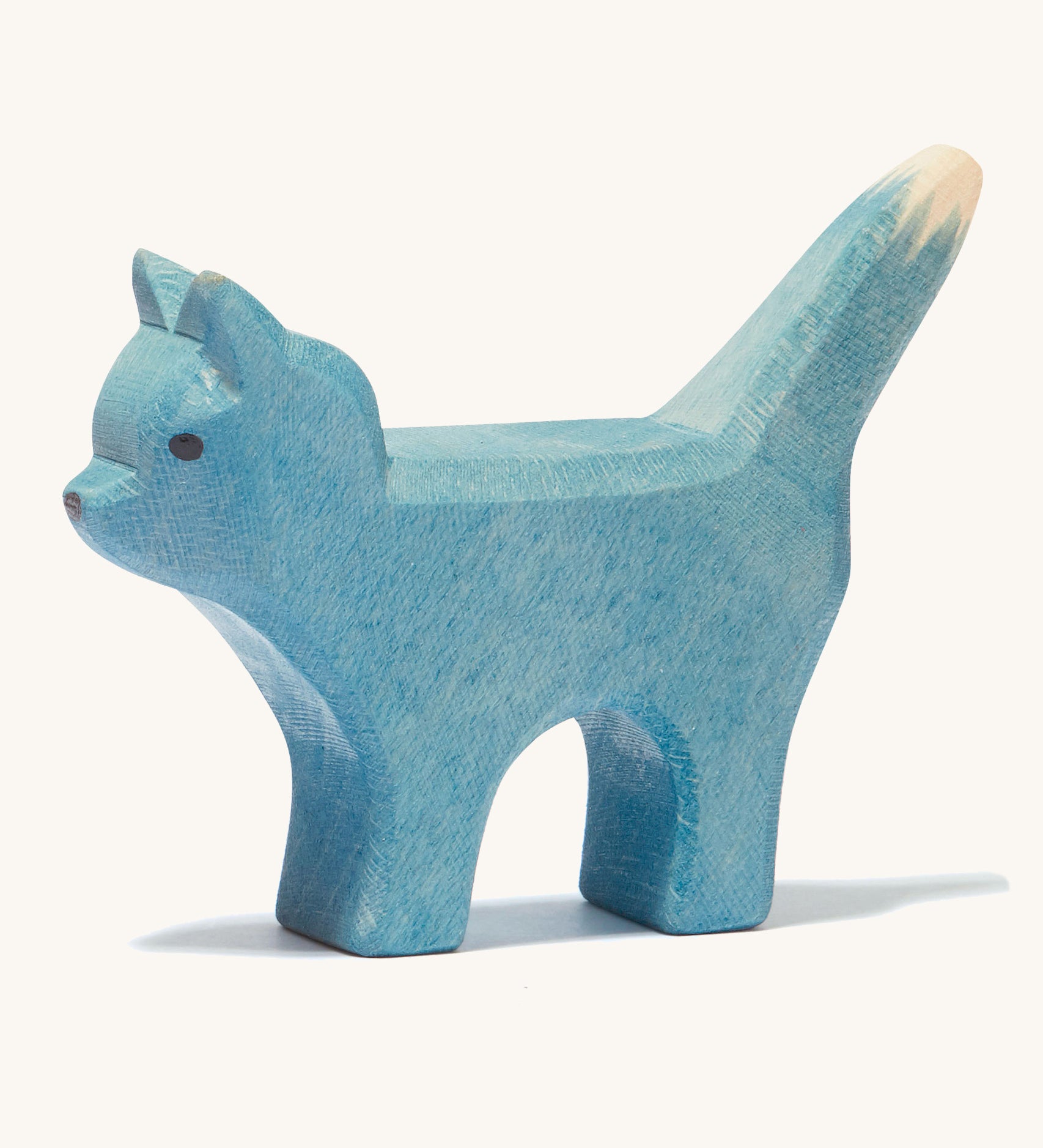 A blue wooden Ostheimer bremer standing cat figure on a cream background.