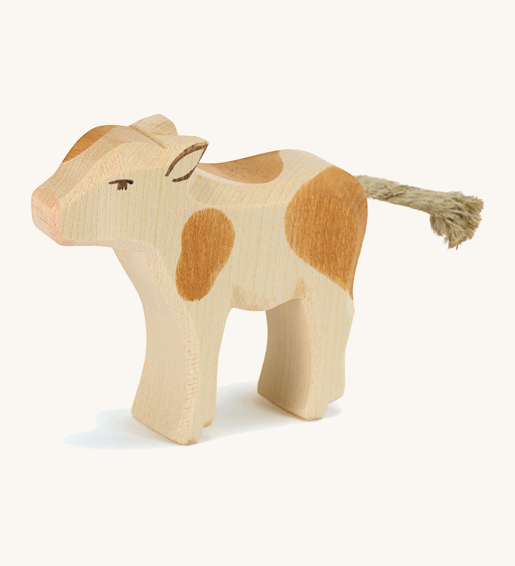 A wooden brown and white Ostheimer standing calf on a cream background.