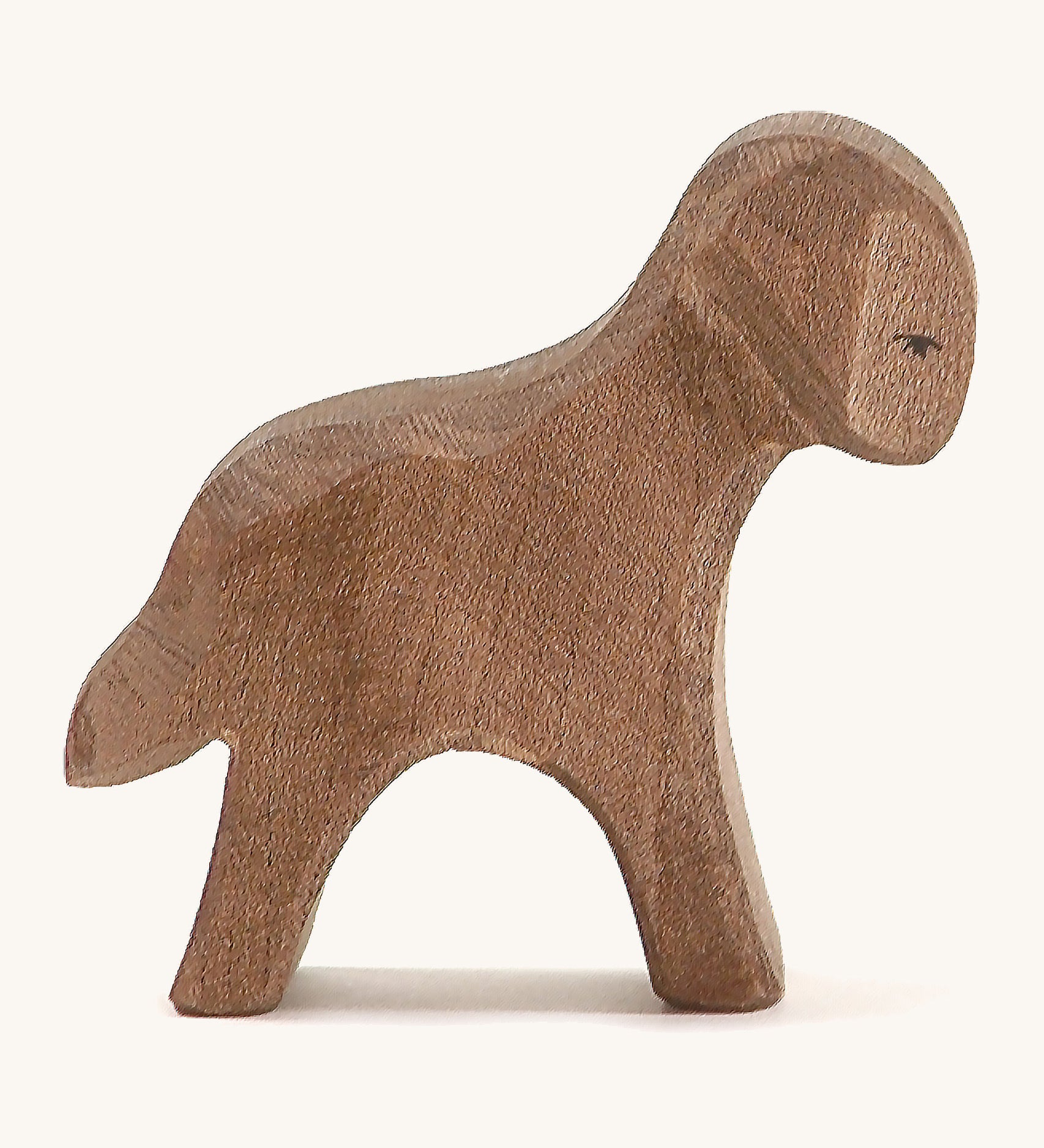 A brown wooden standing Ostheimer lamb figure on a cream background.