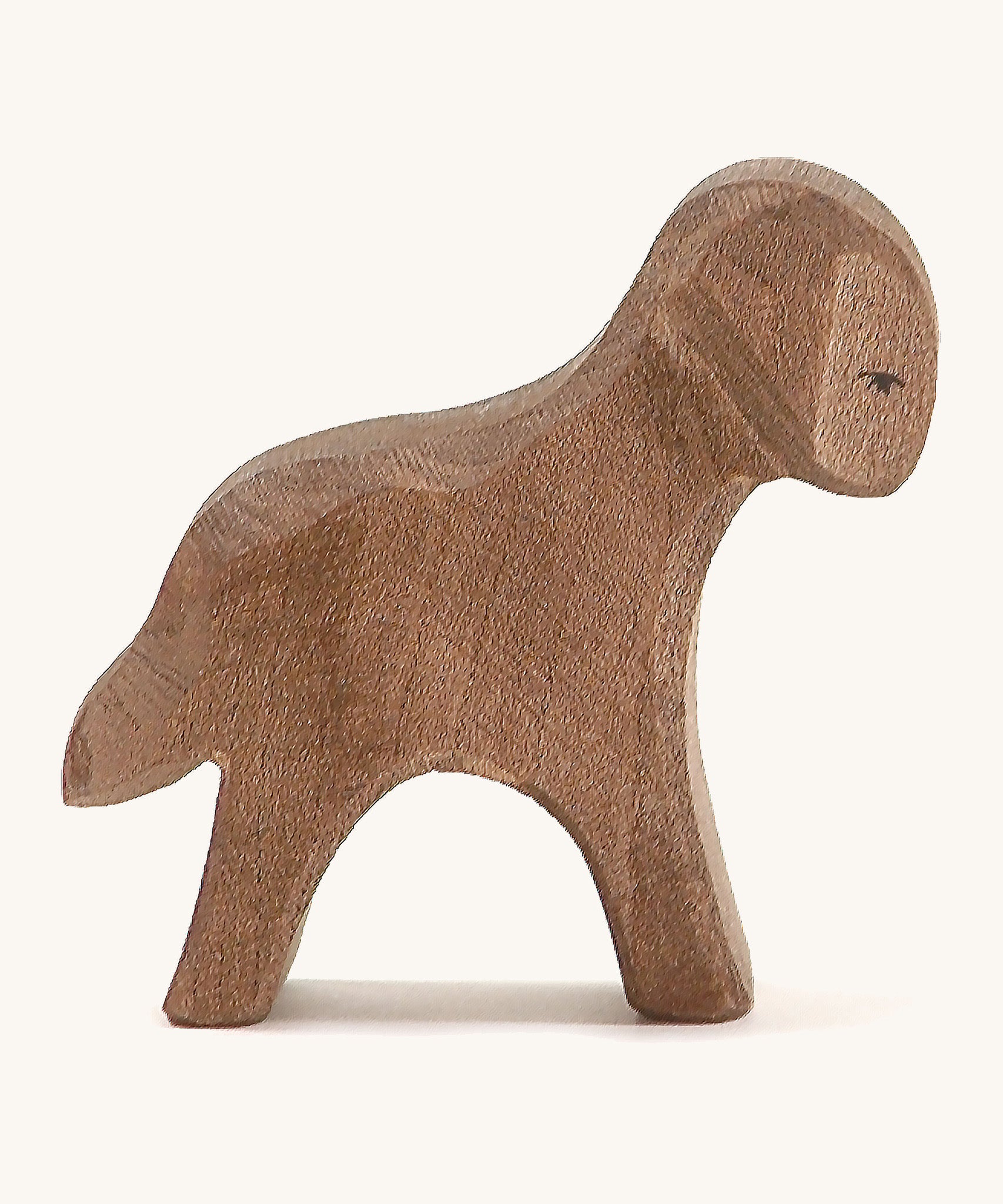 A brown wooden standing Ostheimer lamb figure on a cream background.