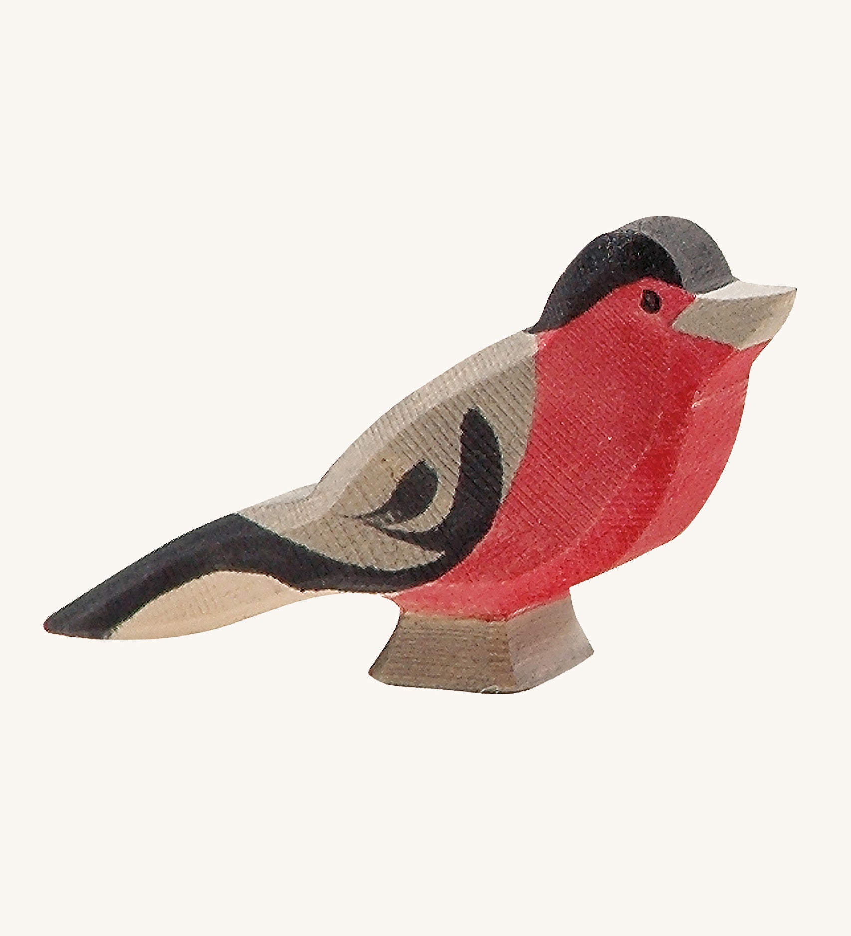 A wooden Ostheimer bullfinch bird figure on a cream background