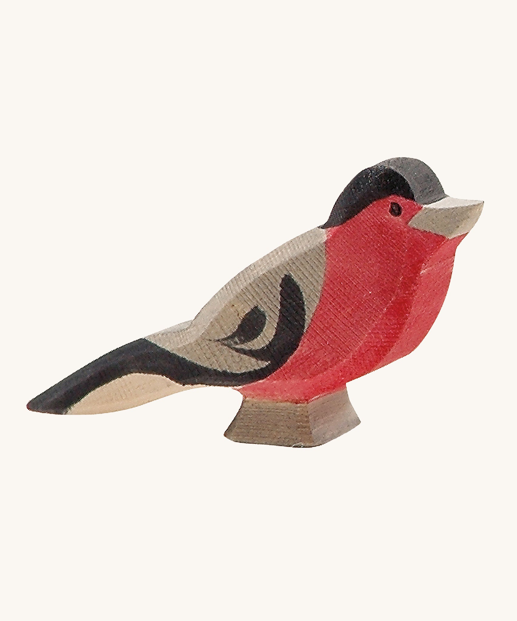 A wooden Ostheimer bullfinch bird figure on a cream background