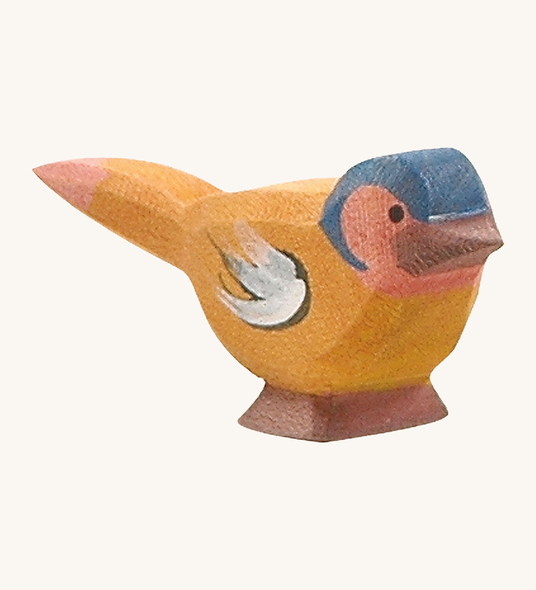 A wooden Ostheimer chaffinch bird figure on a cream background.