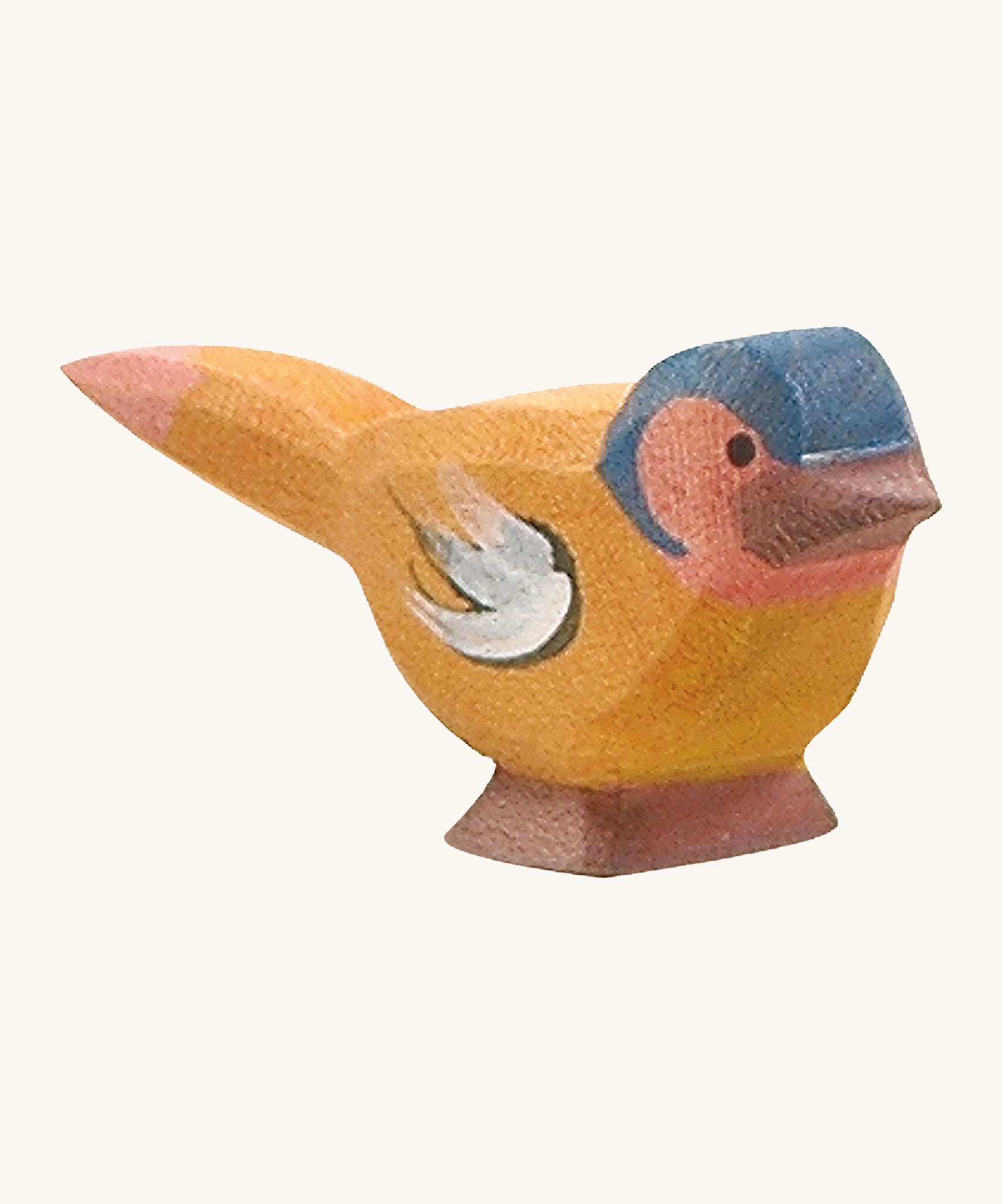 A wooden Ostheimer chaffinch bird figure on a cream background.