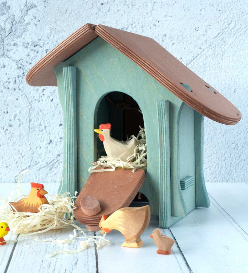 A wooden Ostheimer chicken house with Ostheimer chickens and hens outside