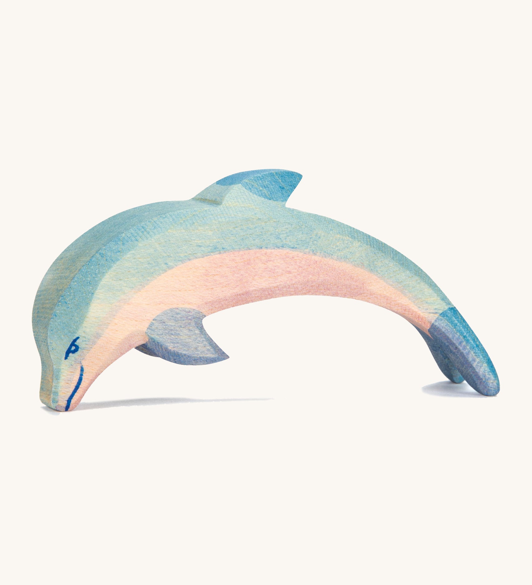 A wooden Ostheimer diving dolphin figure on a cream background.