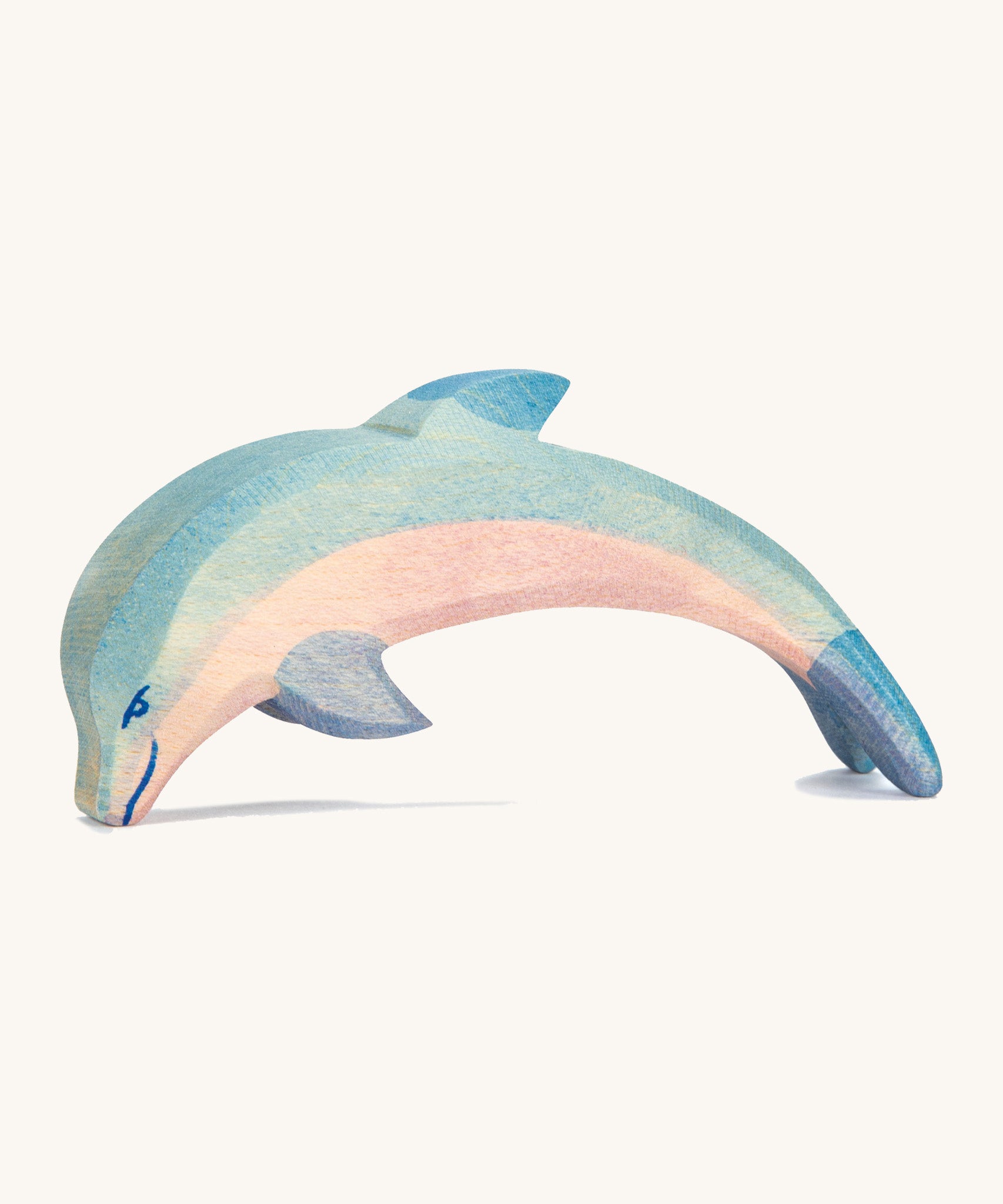 A wooden Ostheimer diving dolphin figure on a cream background.