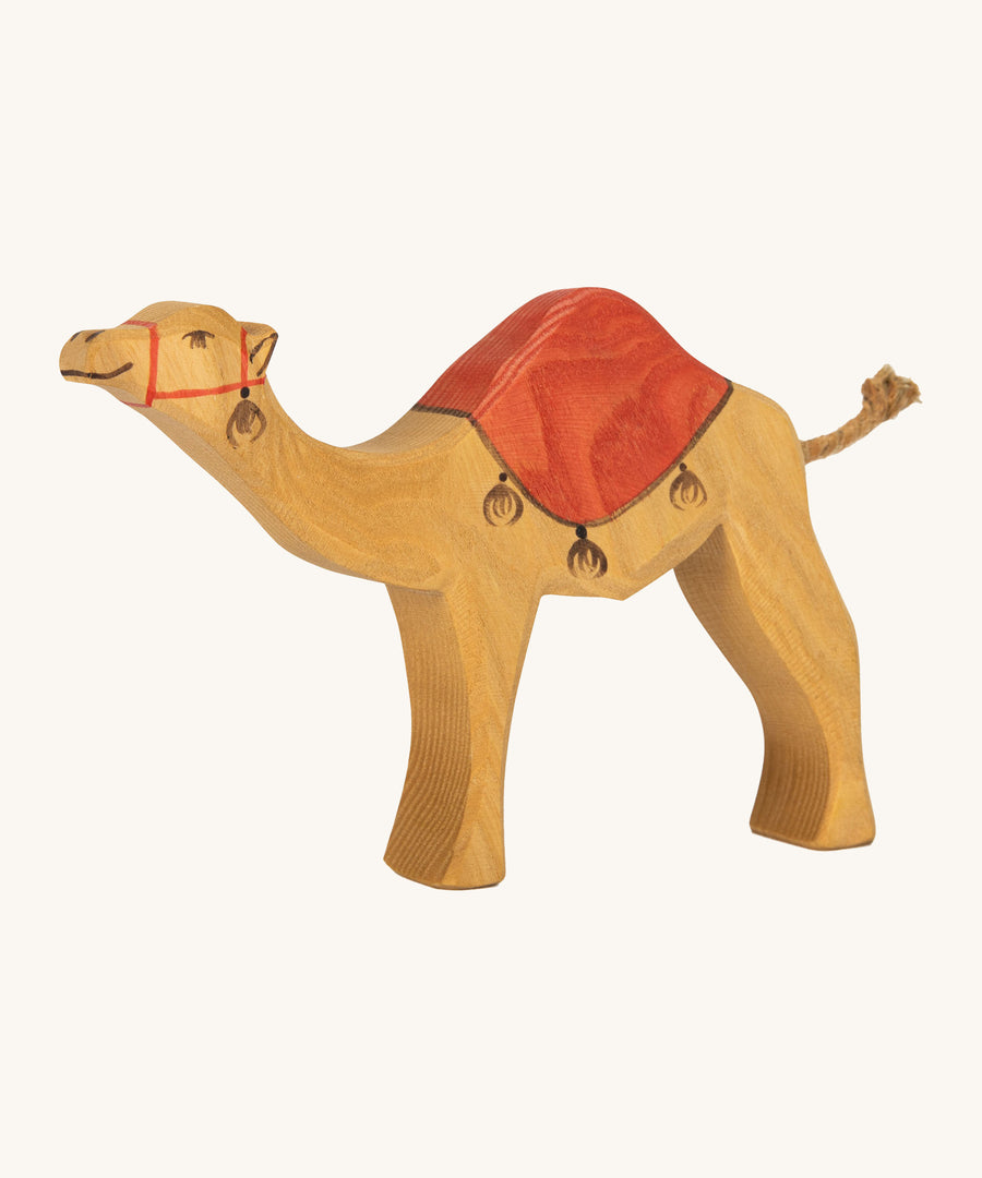 Ostheimer kids handmade wooden dromedary toy figure with red painted saddle on a cream background