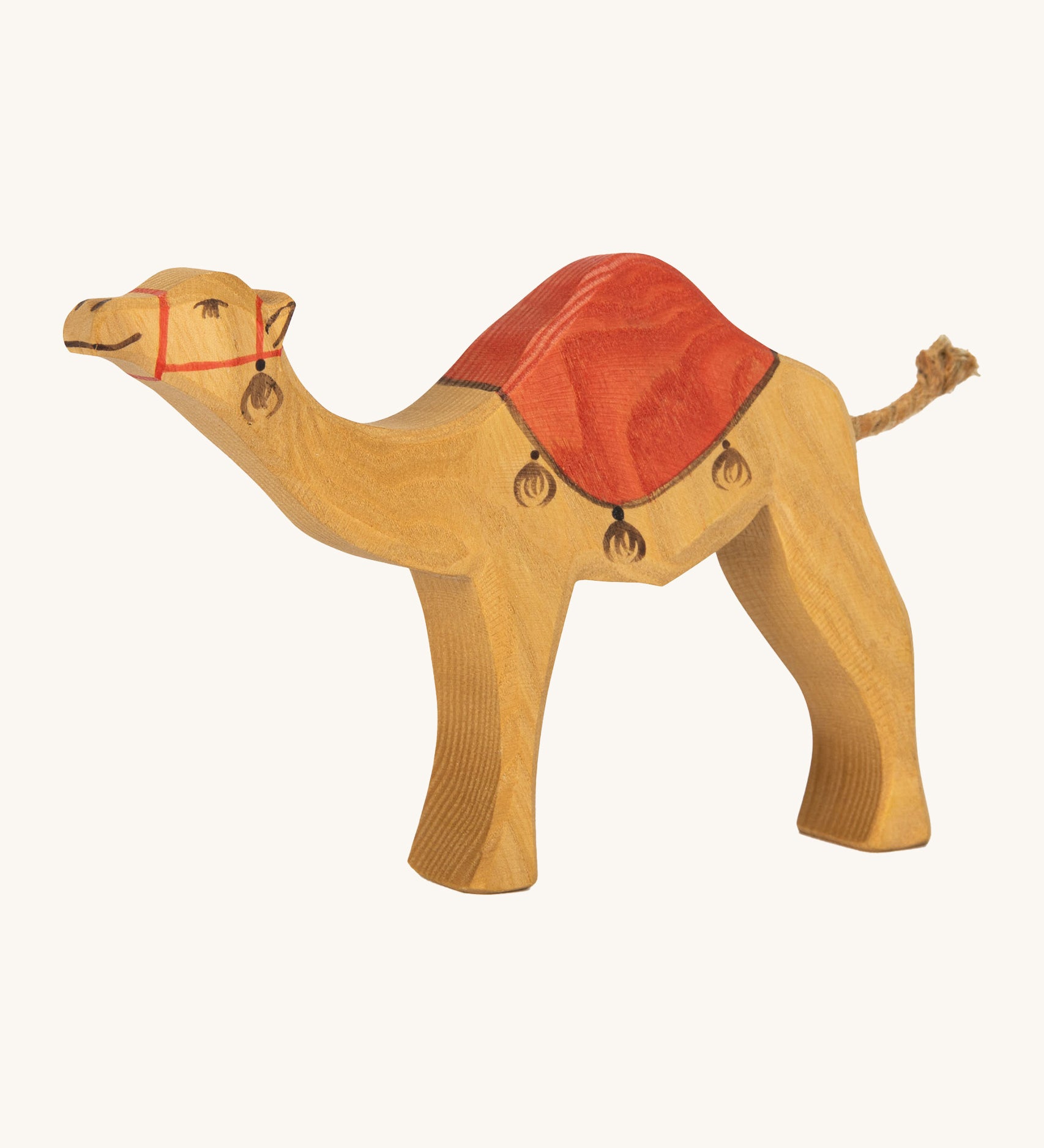 Ostheimer kids handmade wooden dromedary toy figure with red painted saddle on a cream background