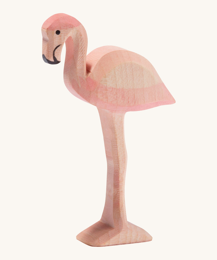 Ostheimer wooden flamingo in pink with black beak on a cream background.