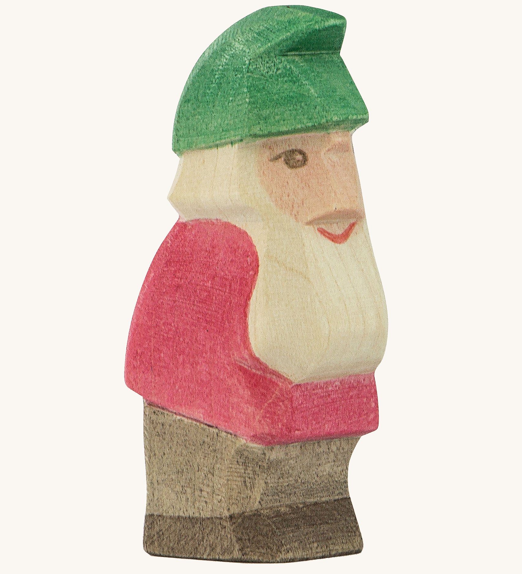 A wooden Ostheimer Fridolin dwarf figure wearing a red top, brown trousers and a green hat on a cream background.