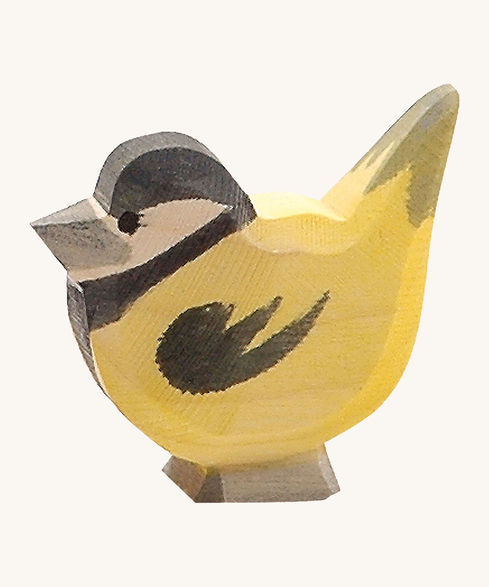 A wooden Ostheimer goldfinch bird figure on a cream background