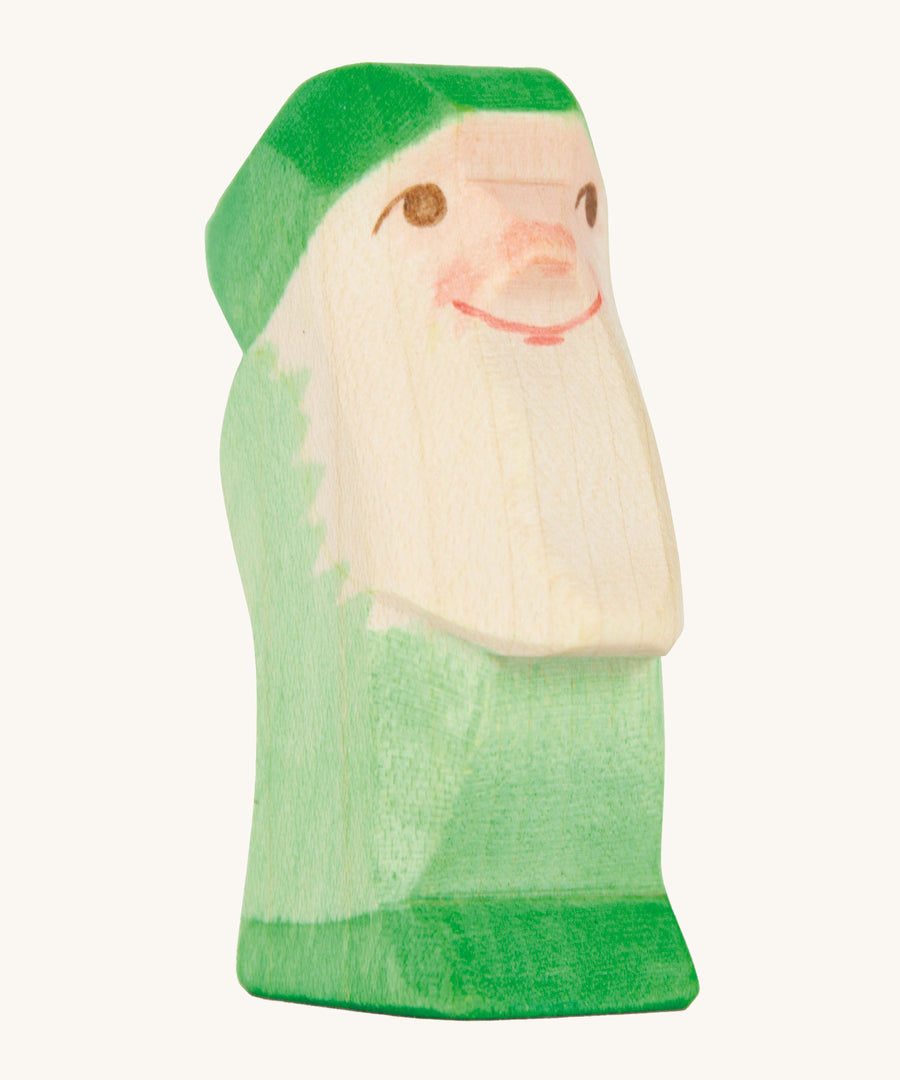 A green wooden Ostheimer dwarf figure on a cream background.