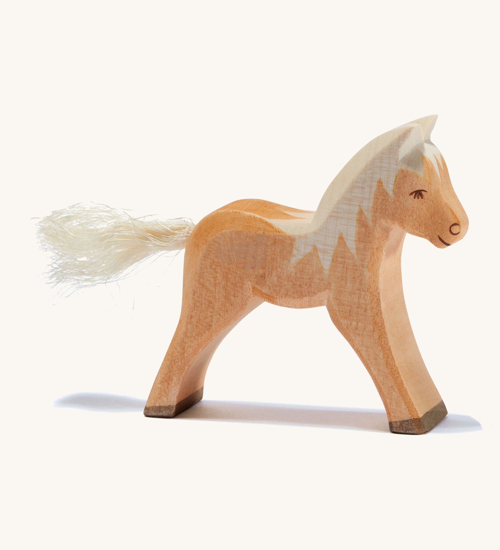 A brown wooden haflinger Ostheimer colt figure on a cream background.