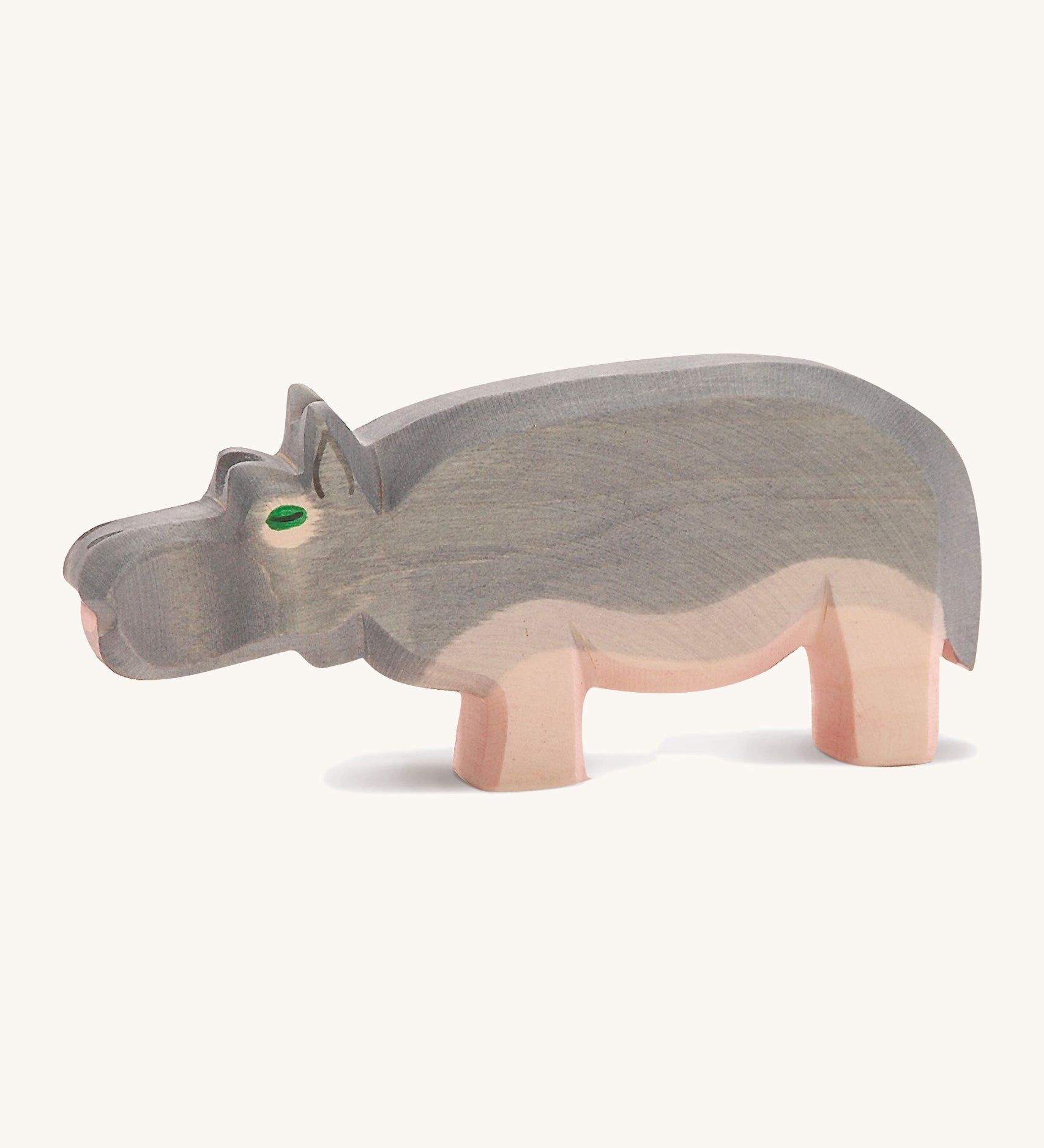 A wooden Ostheimer hippo figure on a cream background.