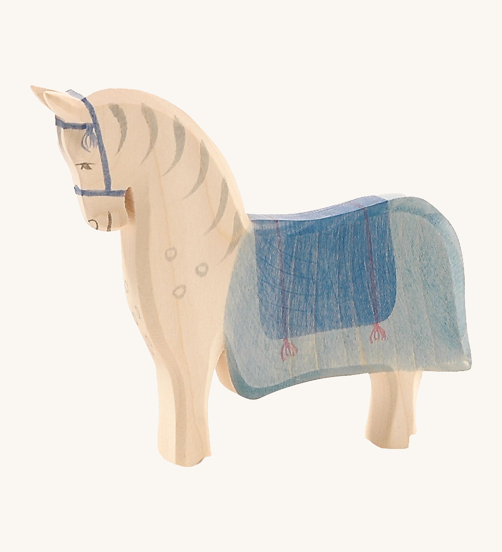 Ostheimer Wooden Horse Figure with a blue painted saddle, on a cream background