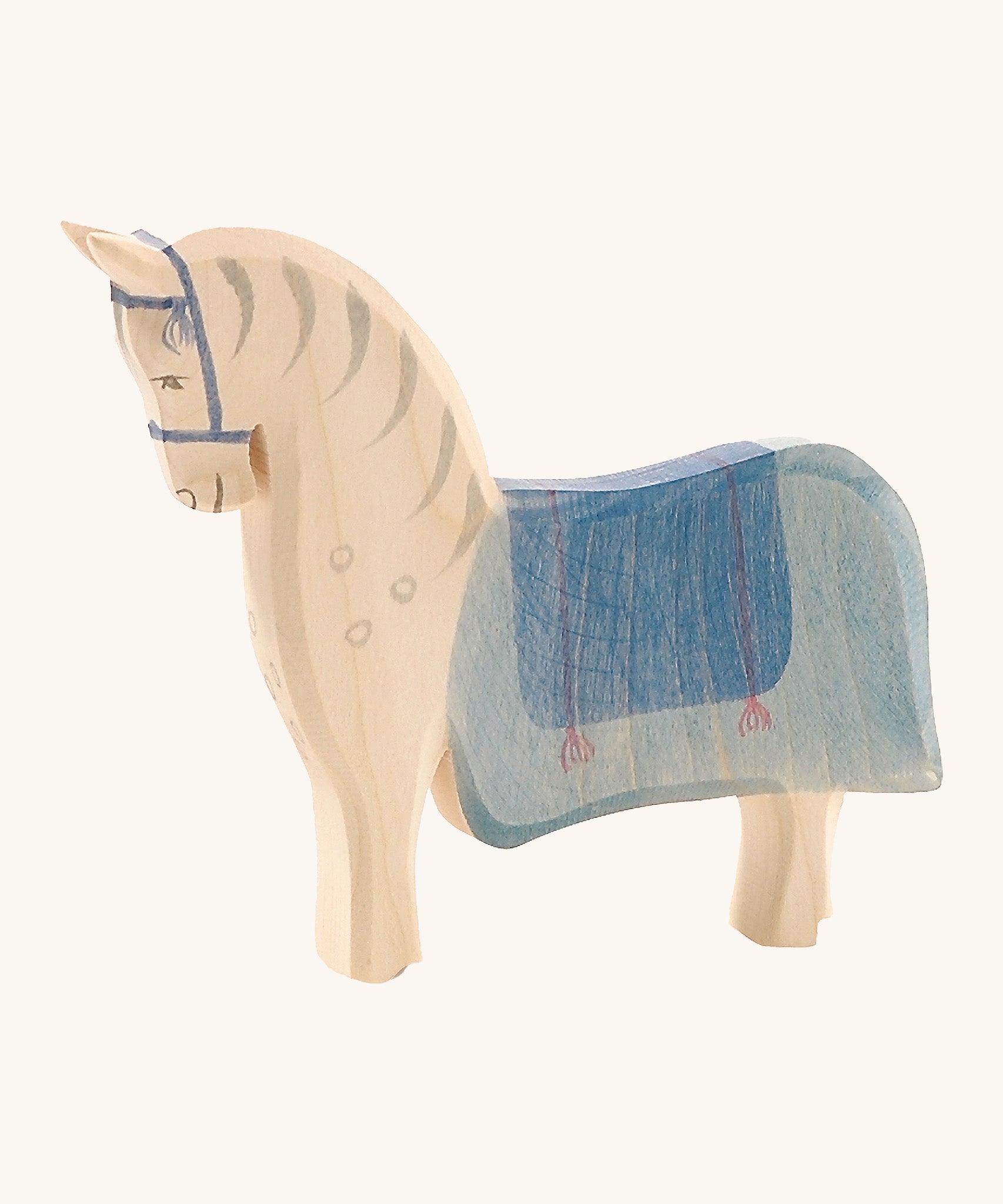 Ostheimer Wooden Horse Figure with a blue painted saddle, on a cream background