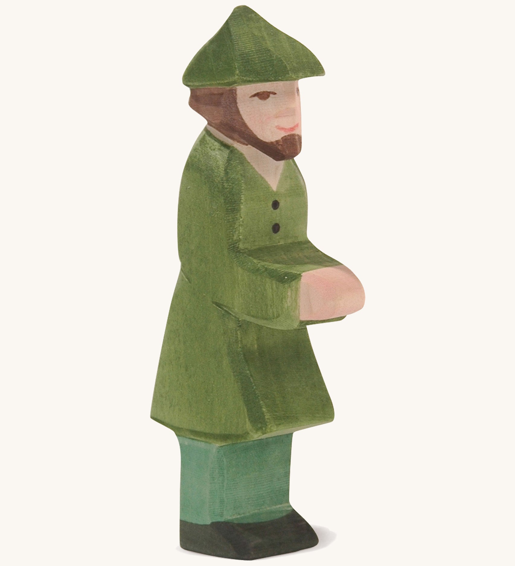 A wooden Ostheimer huntsman figure wearing a green coat and a green hat on a cream background.