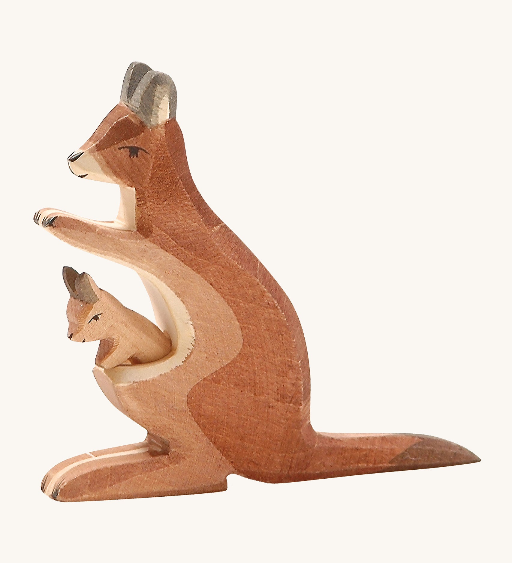 A wooden Ostheimer kangaroo figure with a baby in its pouch on a cream background.