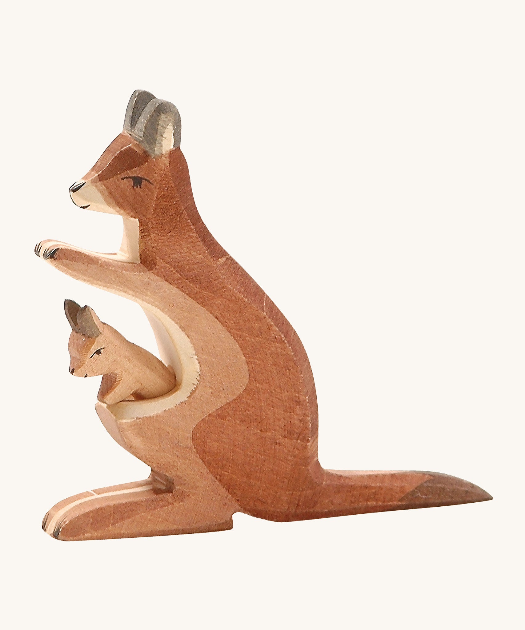 A wooden Ostheimer kangaroo figure with a baby in its pouch on a cream background.