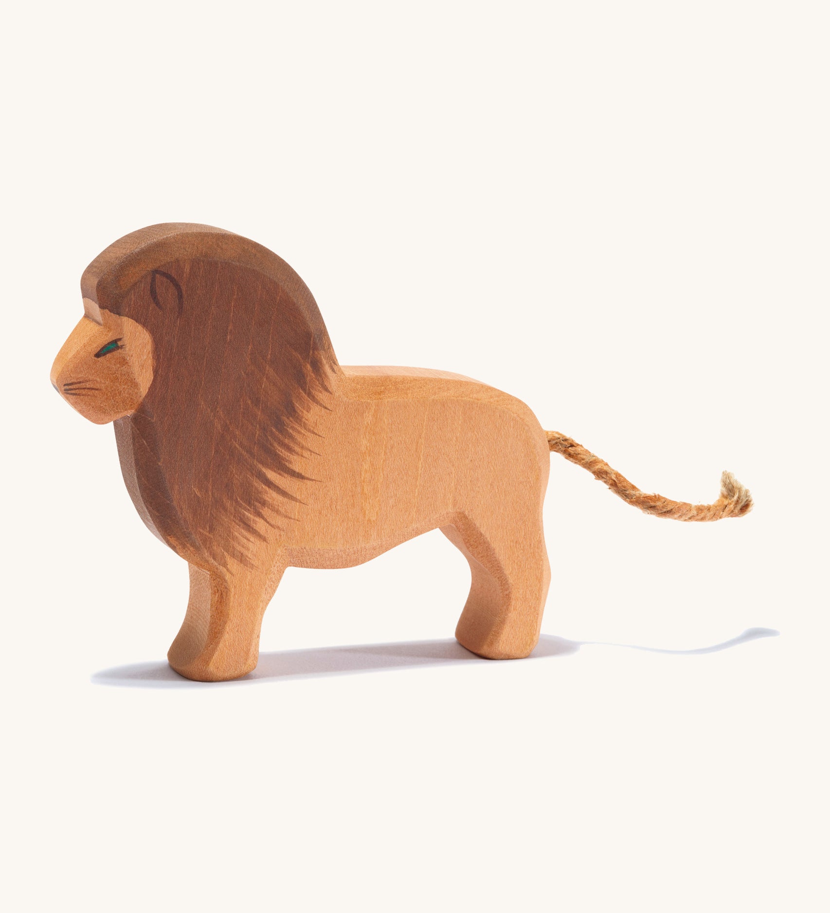 A wooden Ostheimer lion figure on a cream background.