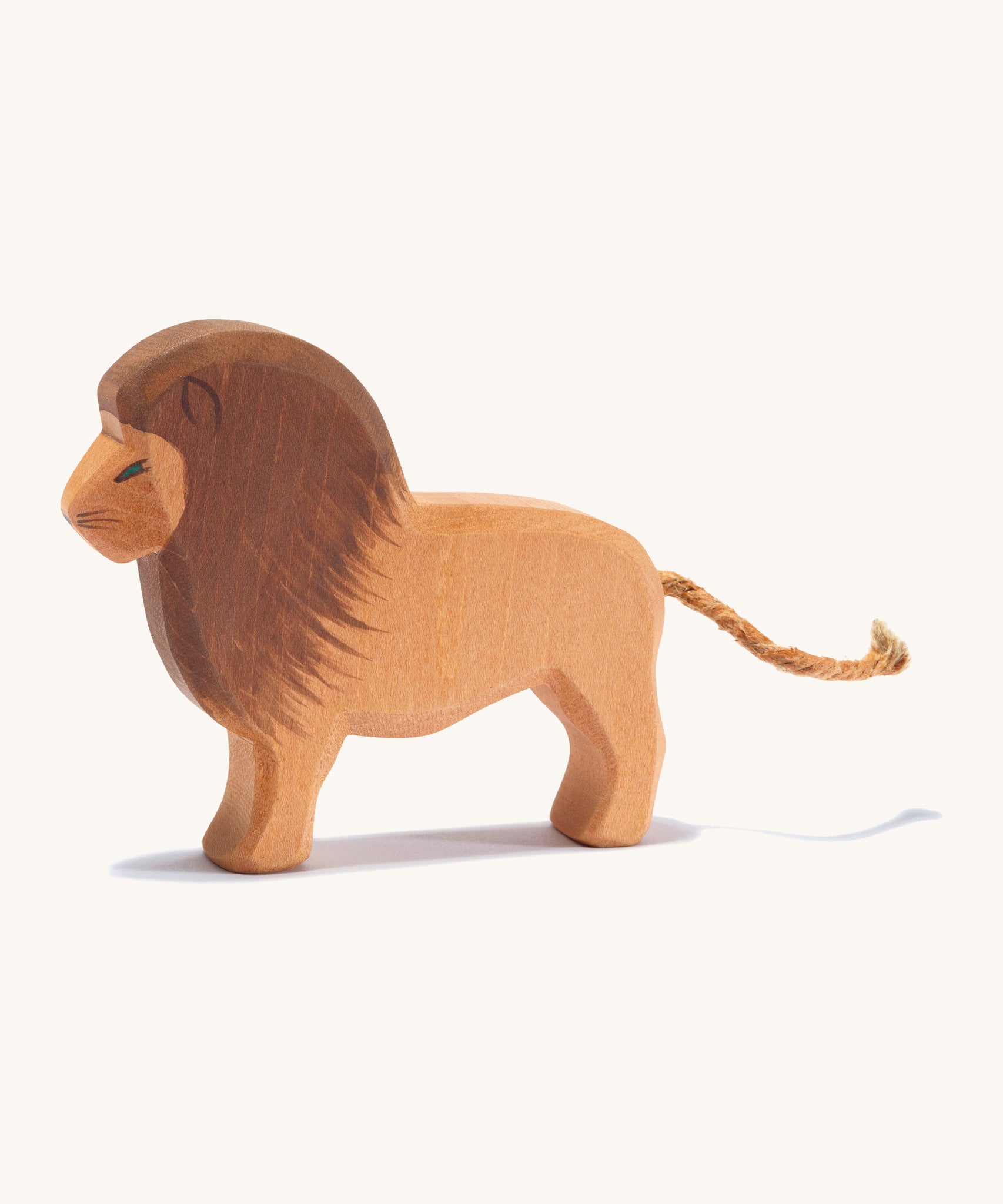 A wooden Ostheimer lion figure on a cream background.