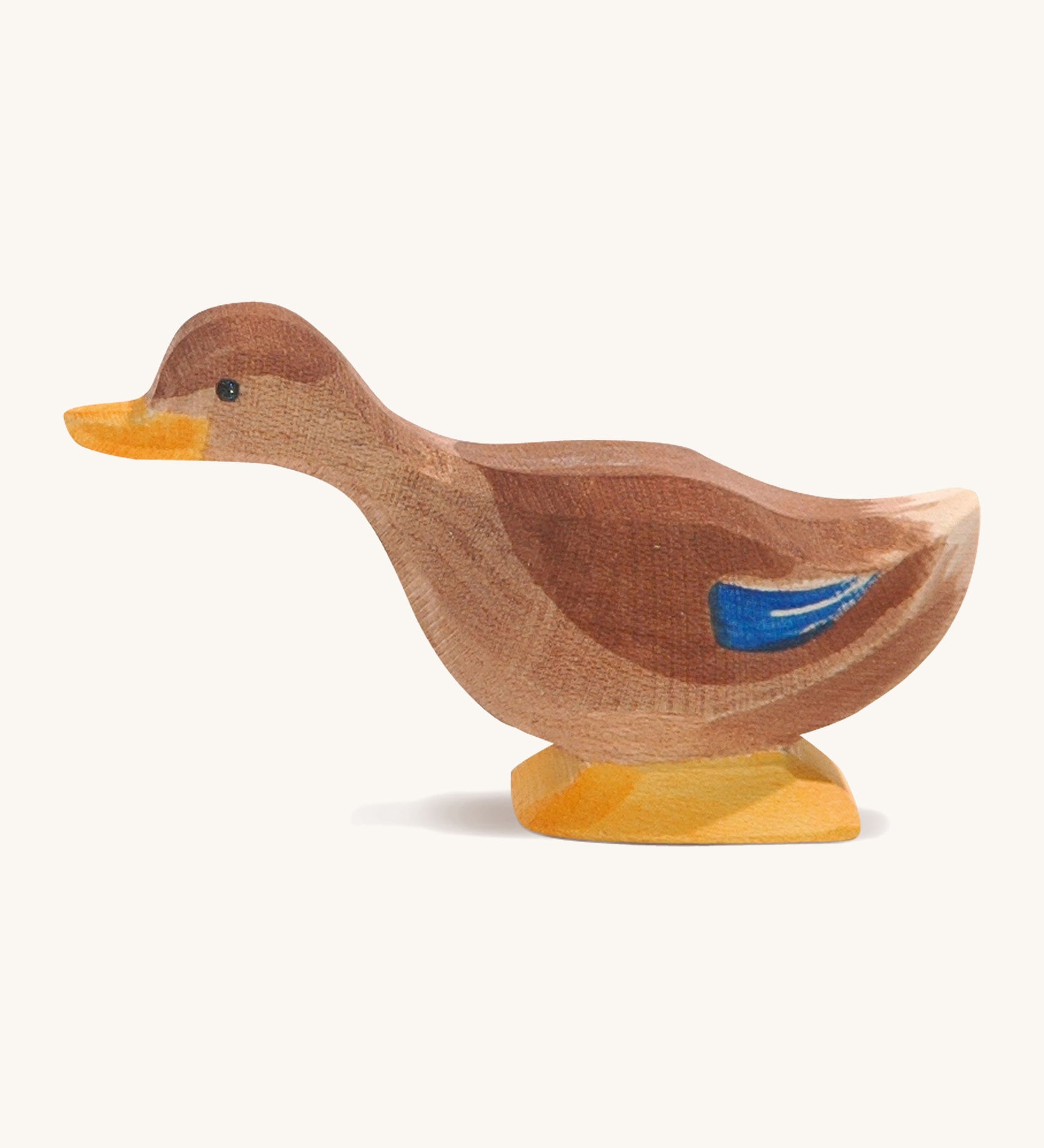 A brown wooden Ostheimer duck with a long neck on a cream background