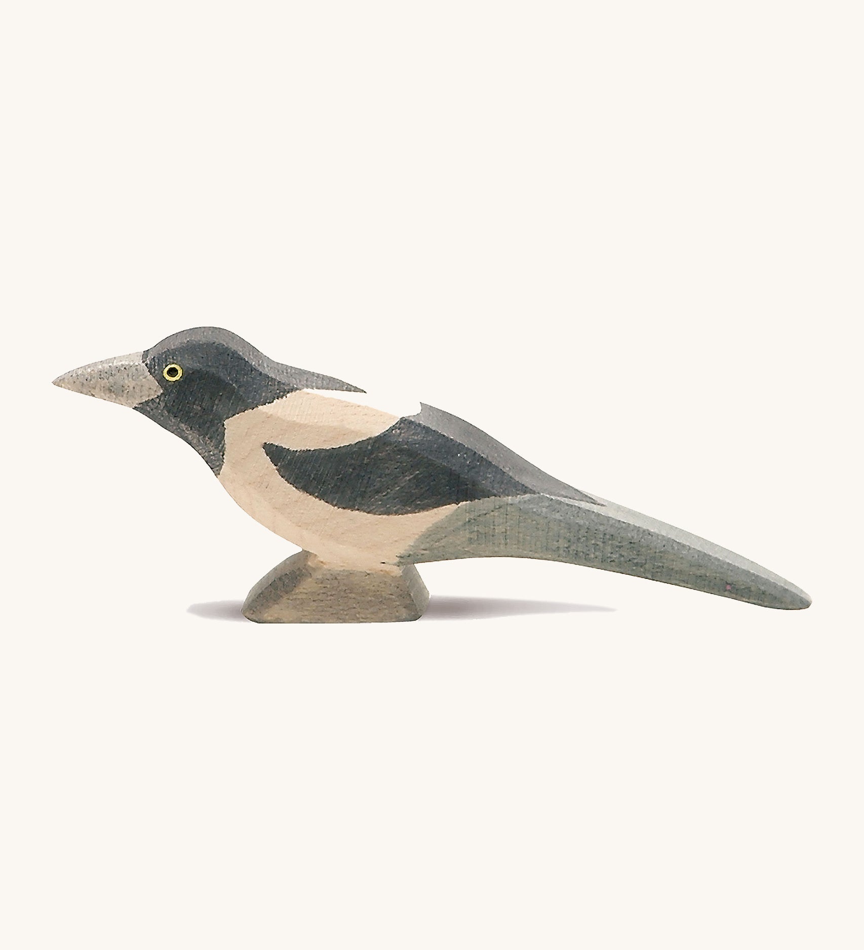 A wooden Ostheimer magpie figure on a cream background.