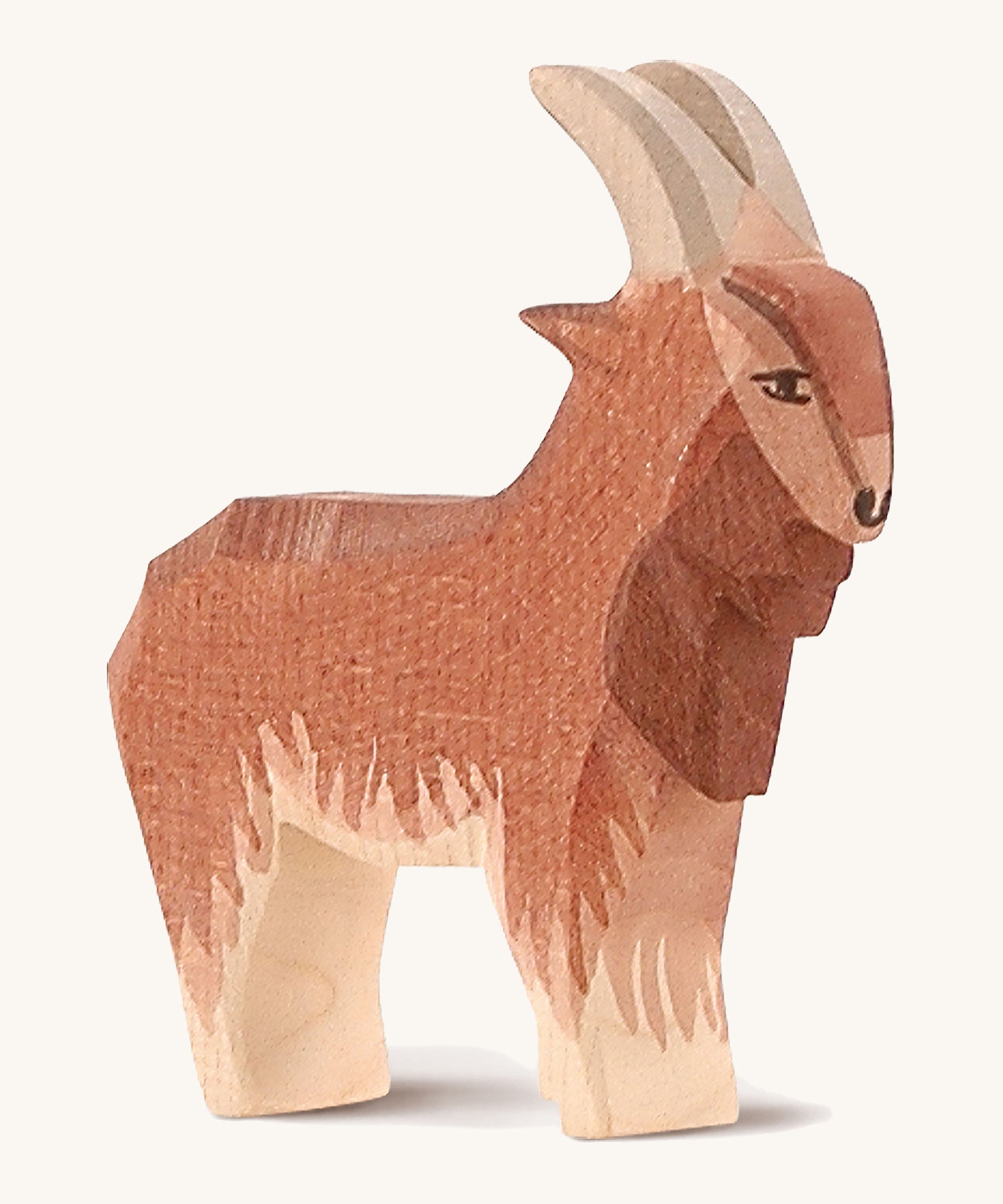 A brown wooden male goat Ostheimer figure on a cream background.