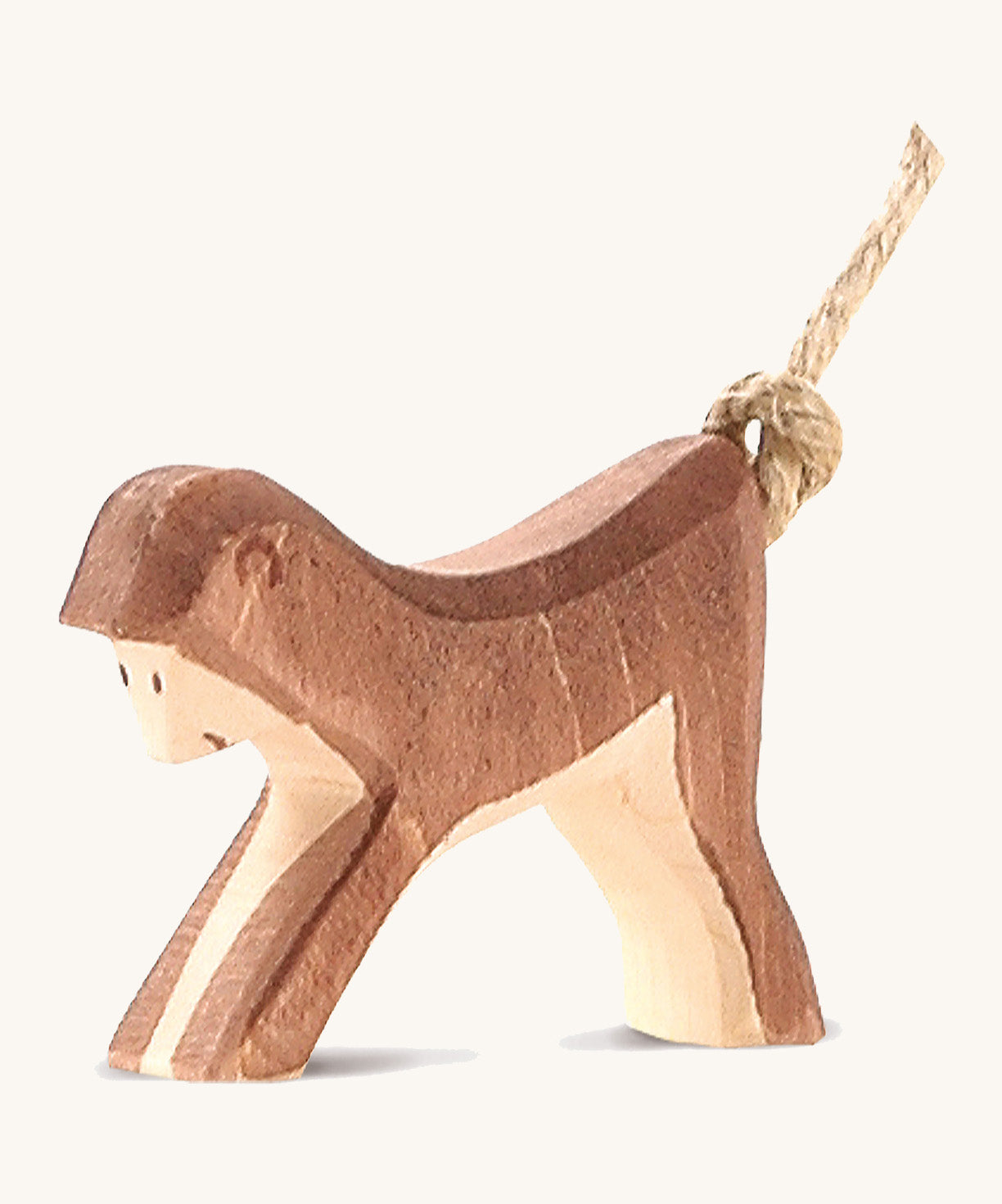 A wooden Ostheimer monkey figure on a cream background.