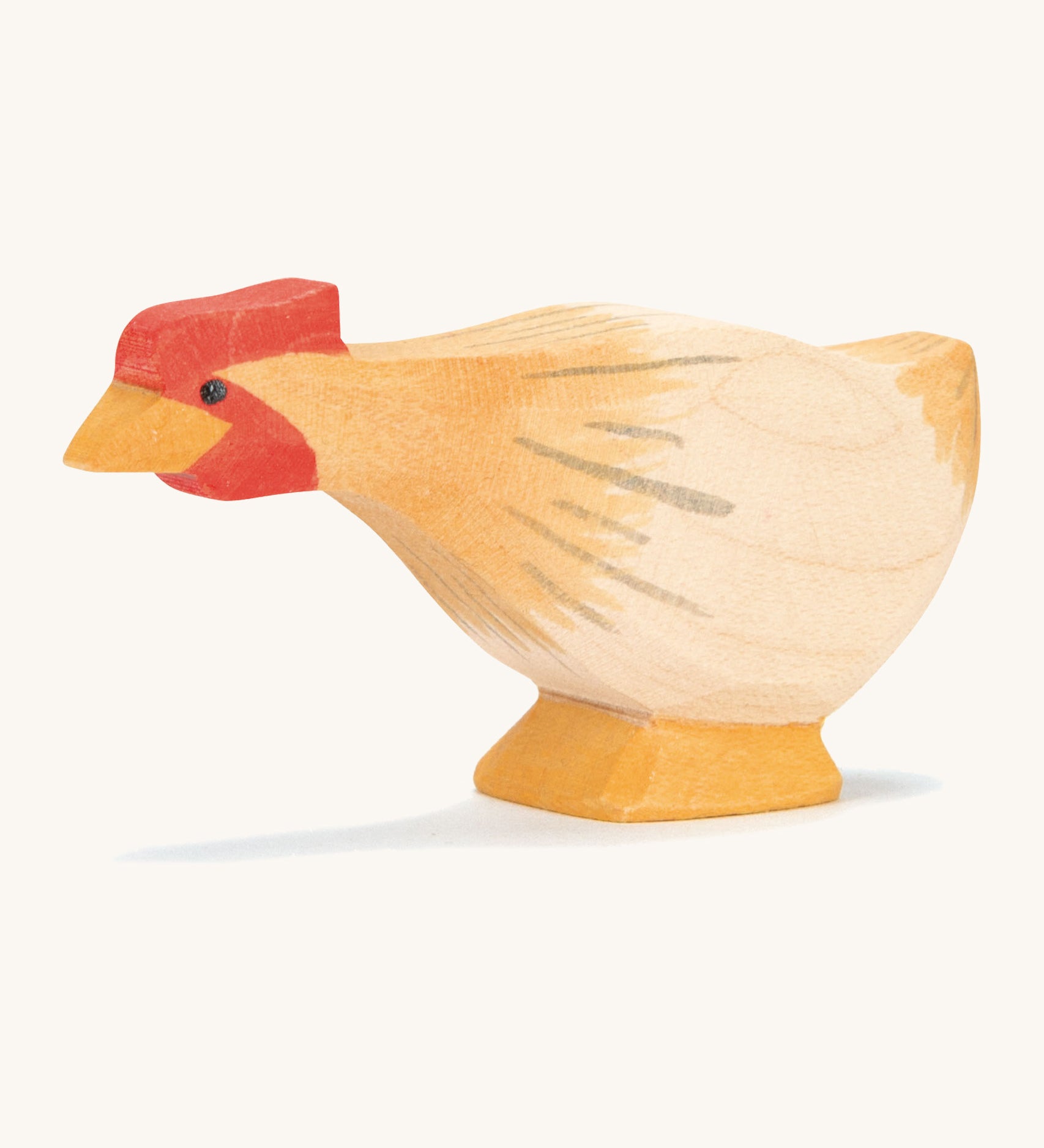 A ochre wooden Ostheimer hen figure with a long neck on a cream background.