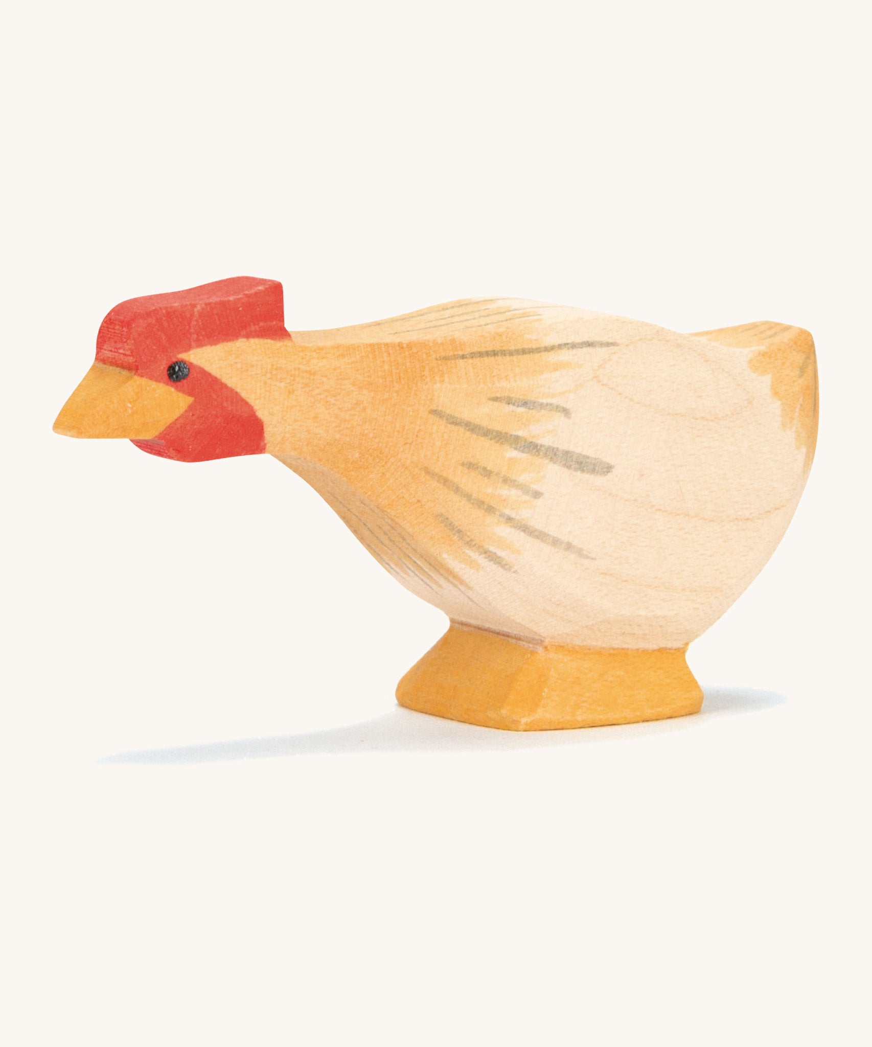 A ochre wooden Ostheimer hen figure with a long neck on a cream background.