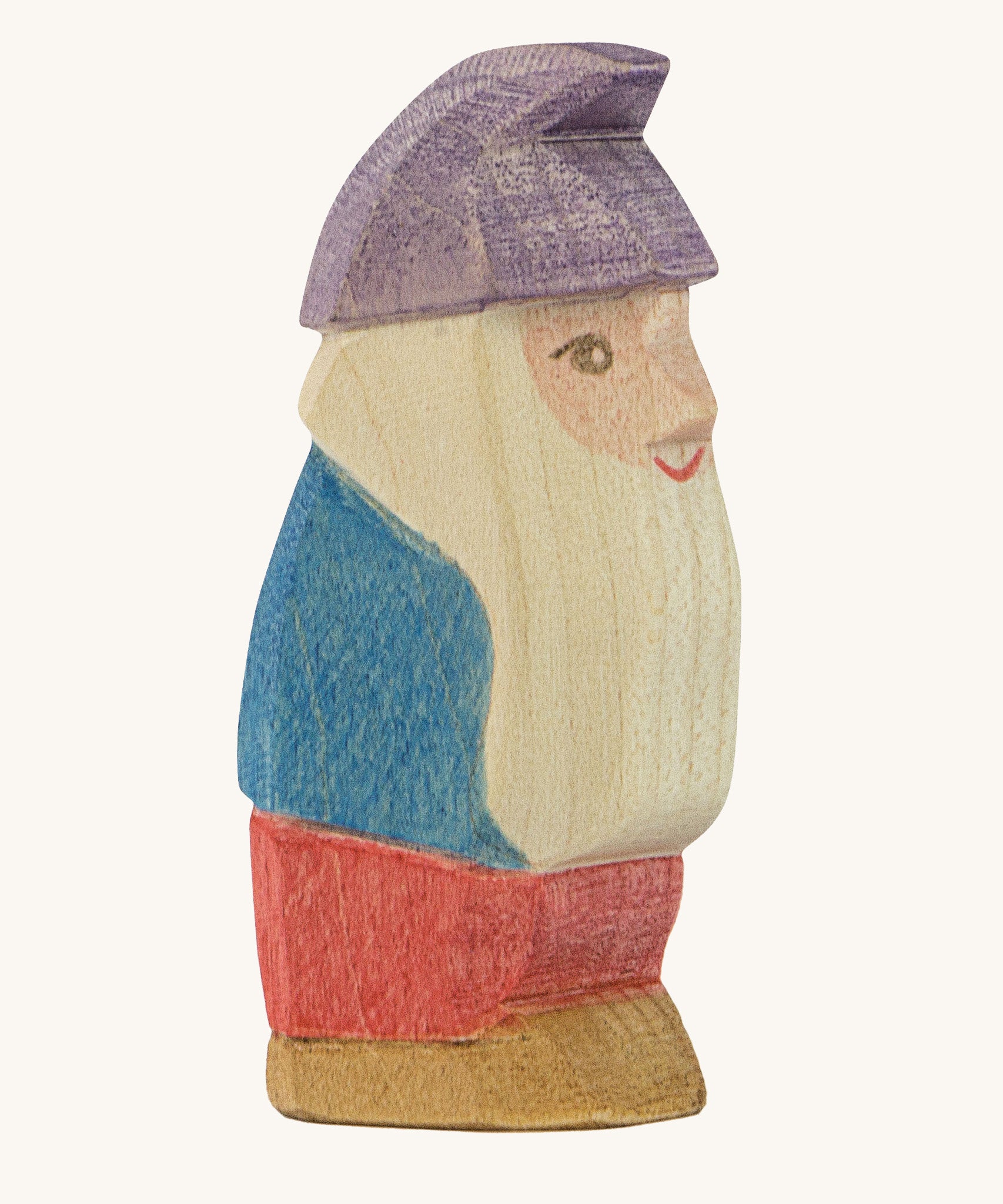 A wooden Ostheimer Paule dwarf figure wearing a blue top, red trousers and a purple hat  on a cream background