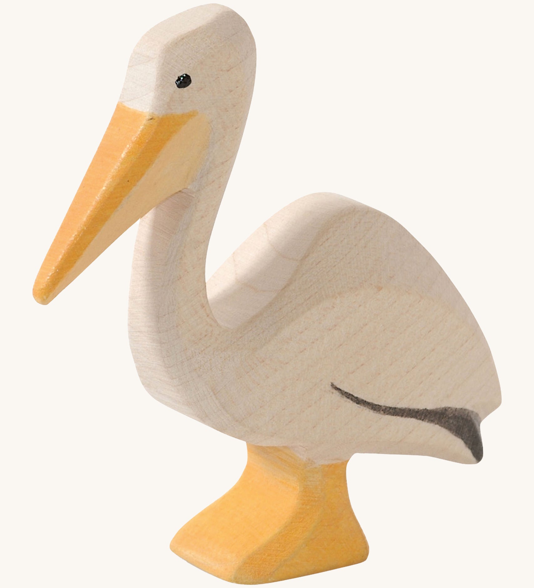 A wooden Ostheimer pelican figure on a cream background.