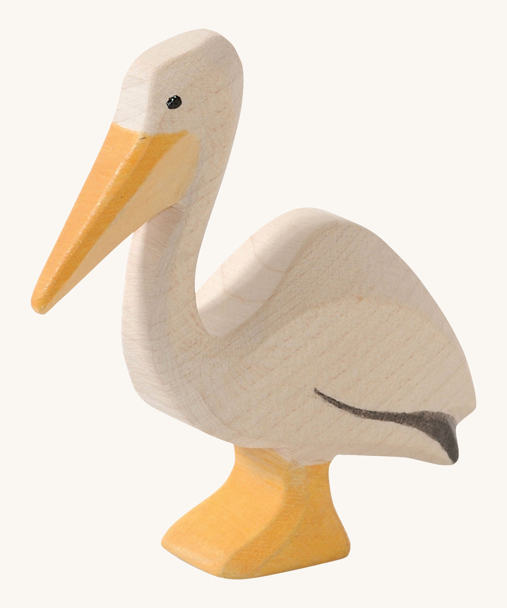 A wooden Ostheimer pelican figure on a cream background.