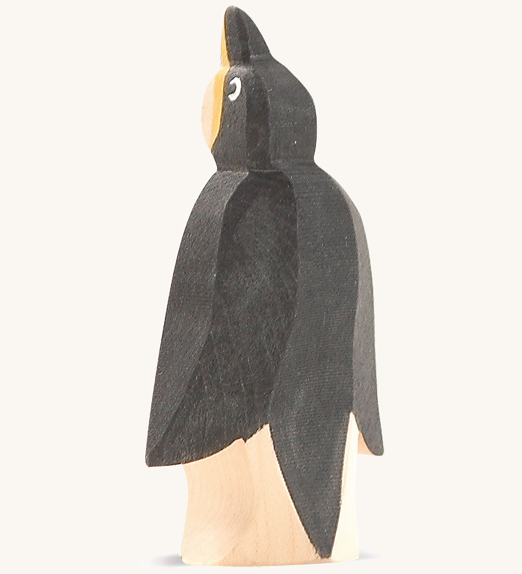 A front wooden Ostheimer penguin figure on a cream background.