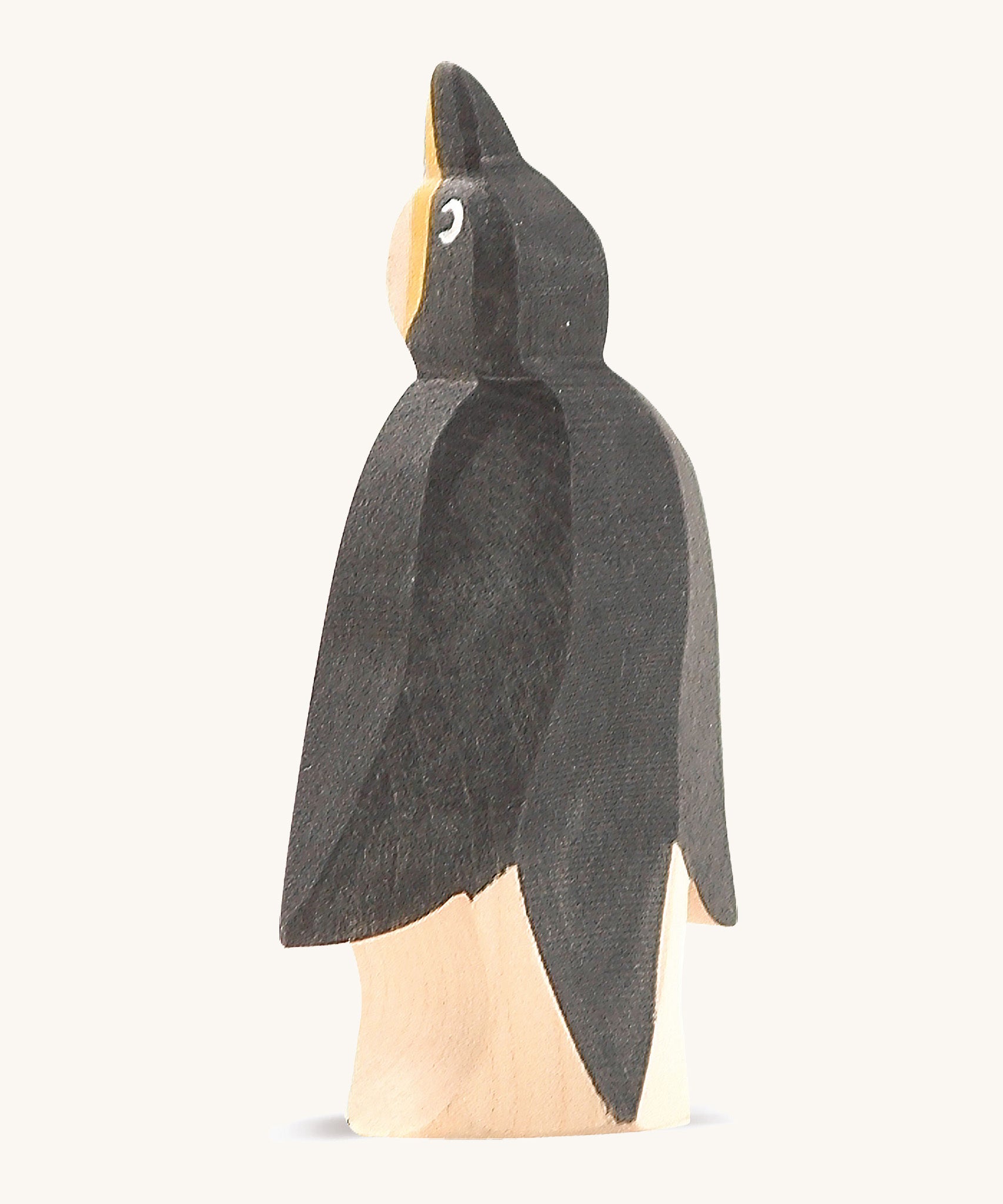 A front wooden Ostheimer penguin figure on a cream background.