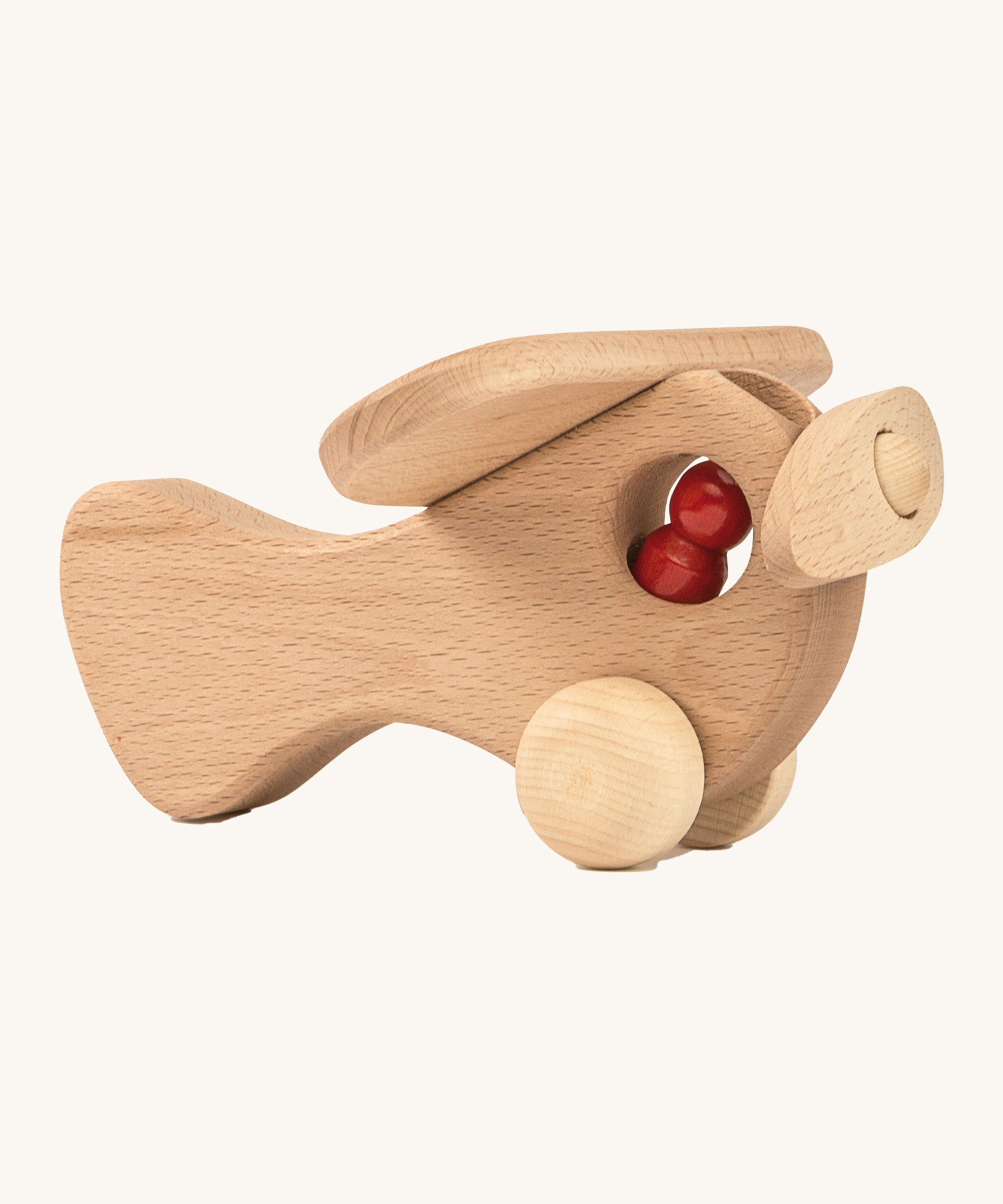 A wooden Ostheimer plane with a red peg doll sitting inside on a cream background.