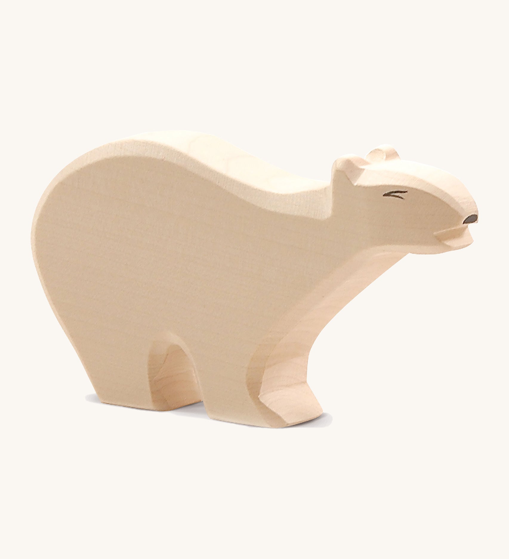 A wooden Ostheimer polar bear figure on a cream background.