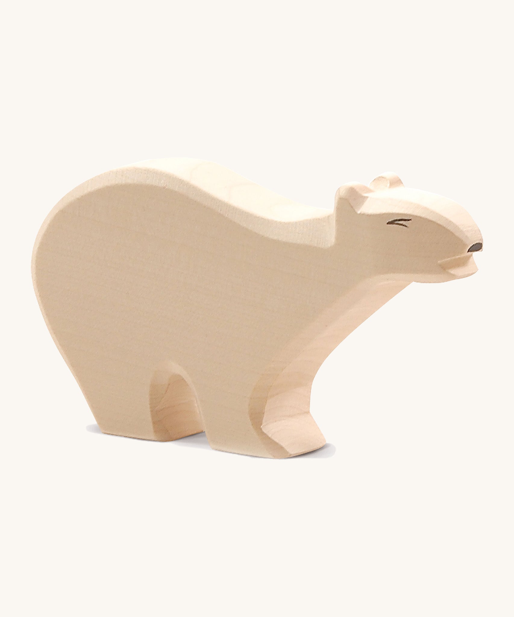 A wooden Ostheimer polar bear figure on a cream background.