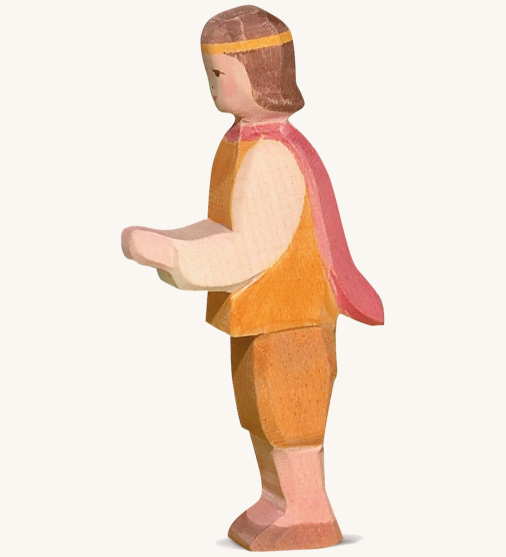 A wooden Ostheimer prince figure wearing a orange and brown outfit with a red cape on a cream background.