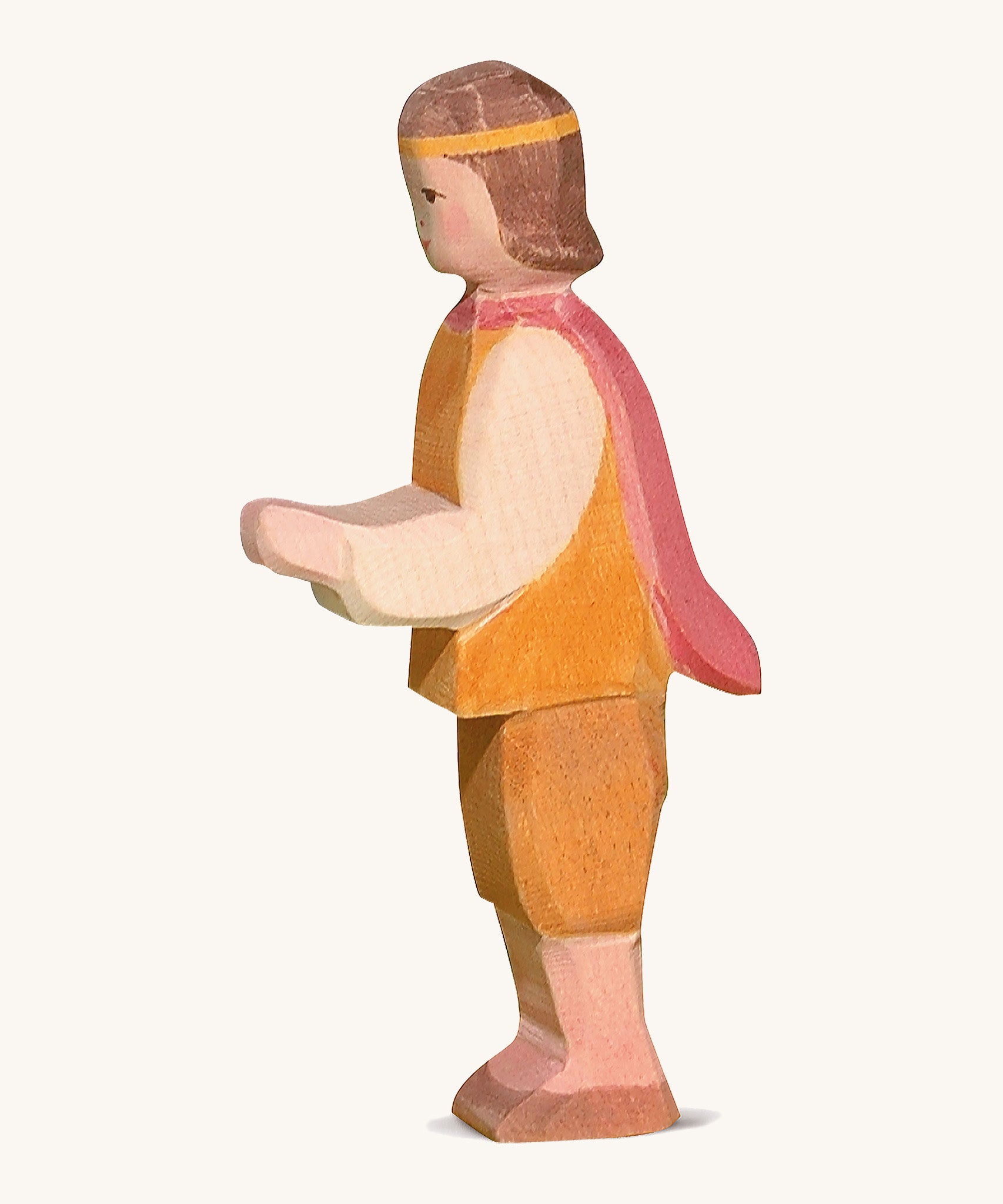 A wooden Ostheimer prince figure wearing a orange and brown outfit with a red cape on a cream background.