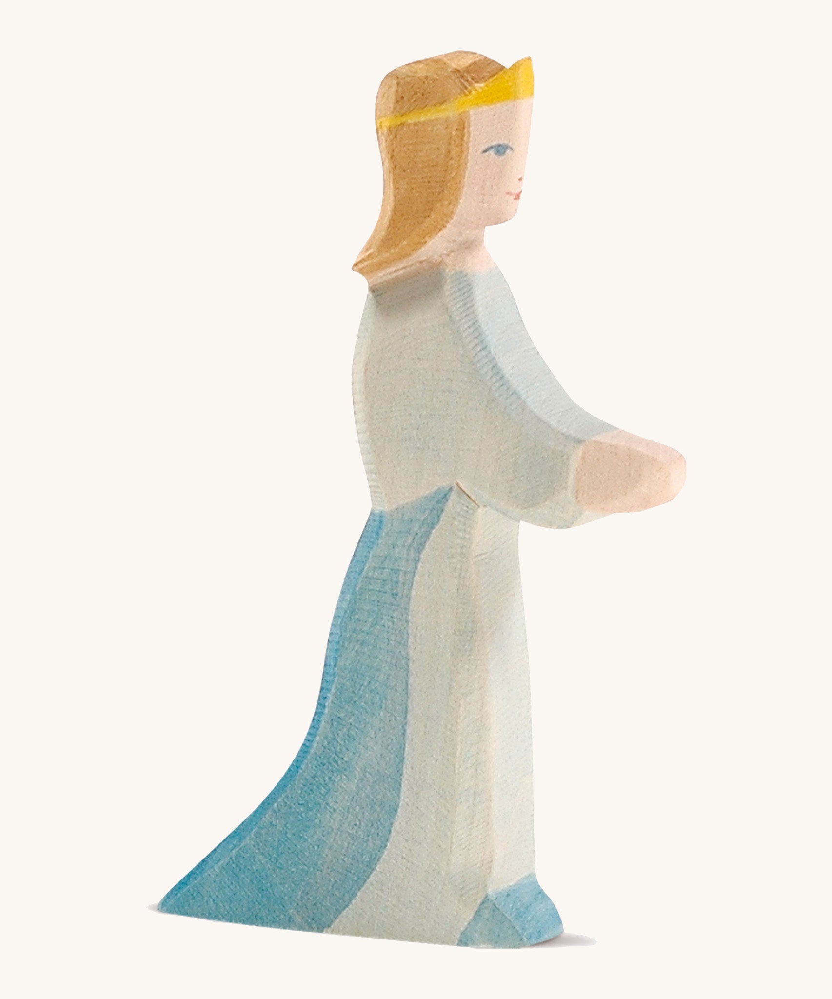 A wooden Ostheimer queen figure wearing a blue flowing dress and yellow tiara on a cream background.