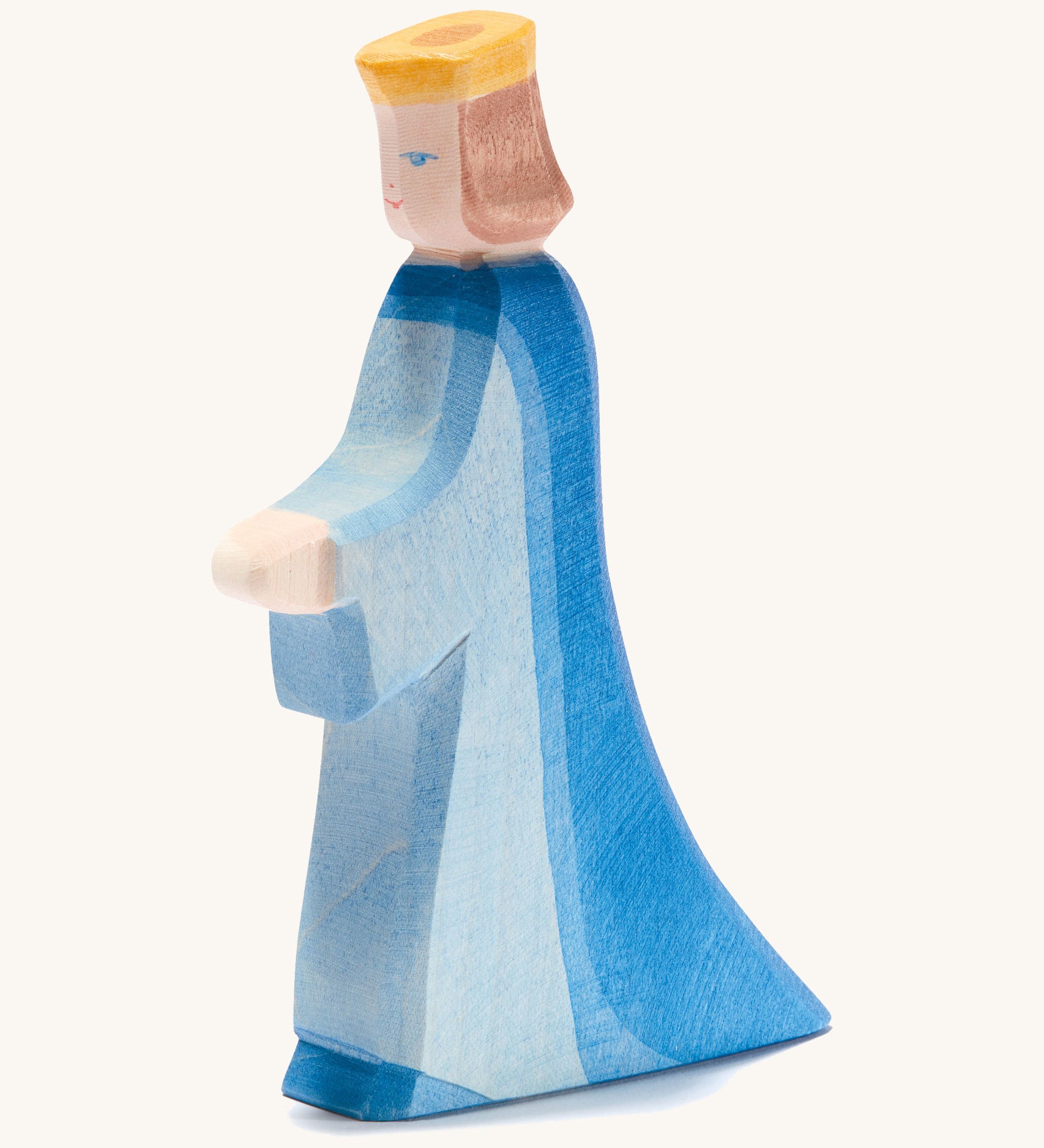 A wooden Ostheimer queen figure wearing a blue flowing dress and yellow crown on a cream background.